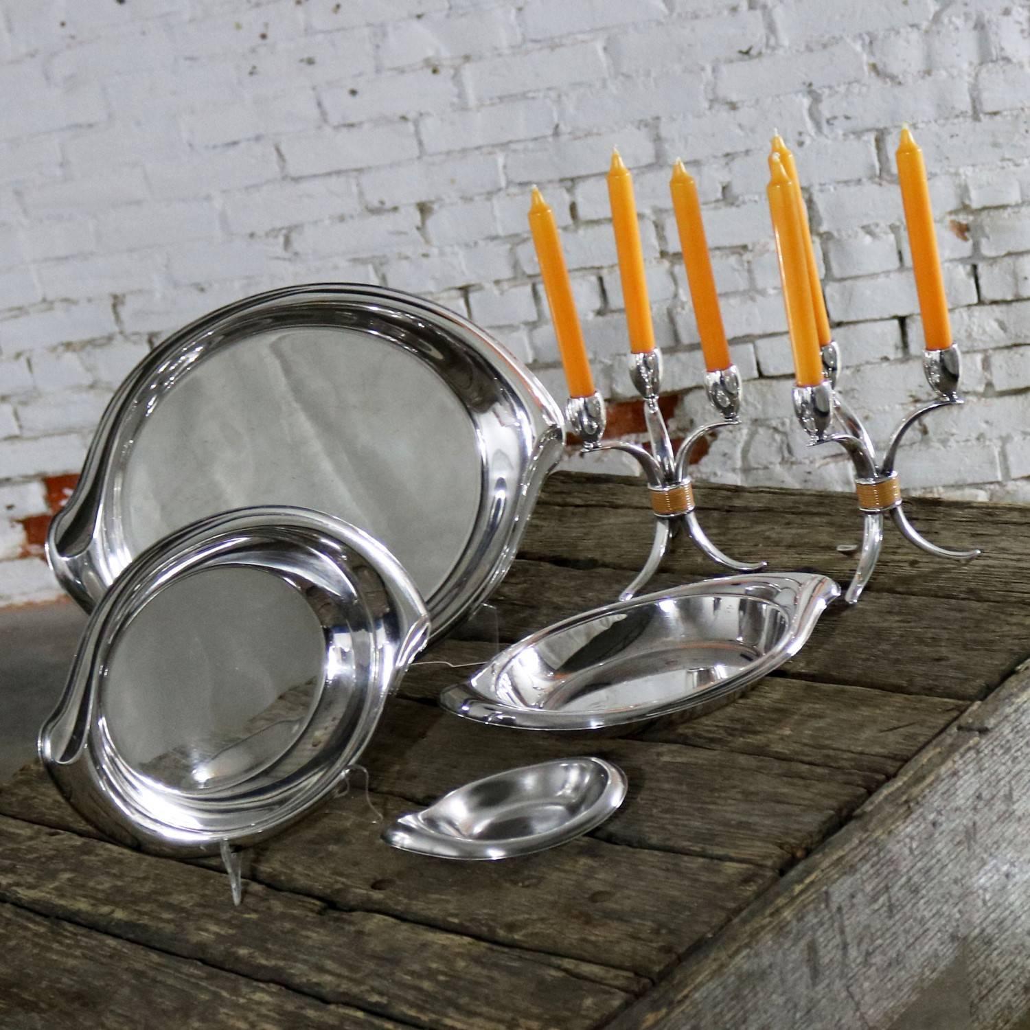 Splendido set di sei pezzi di silver-plate della Rogers & Bros. del 1847. È della linea Flair. Il set comprende un vassoio da portata grande, una coppia di vassoi da portata più piccoli, un piatto da bon bon e una coppia di candelabri. Sono tutti in