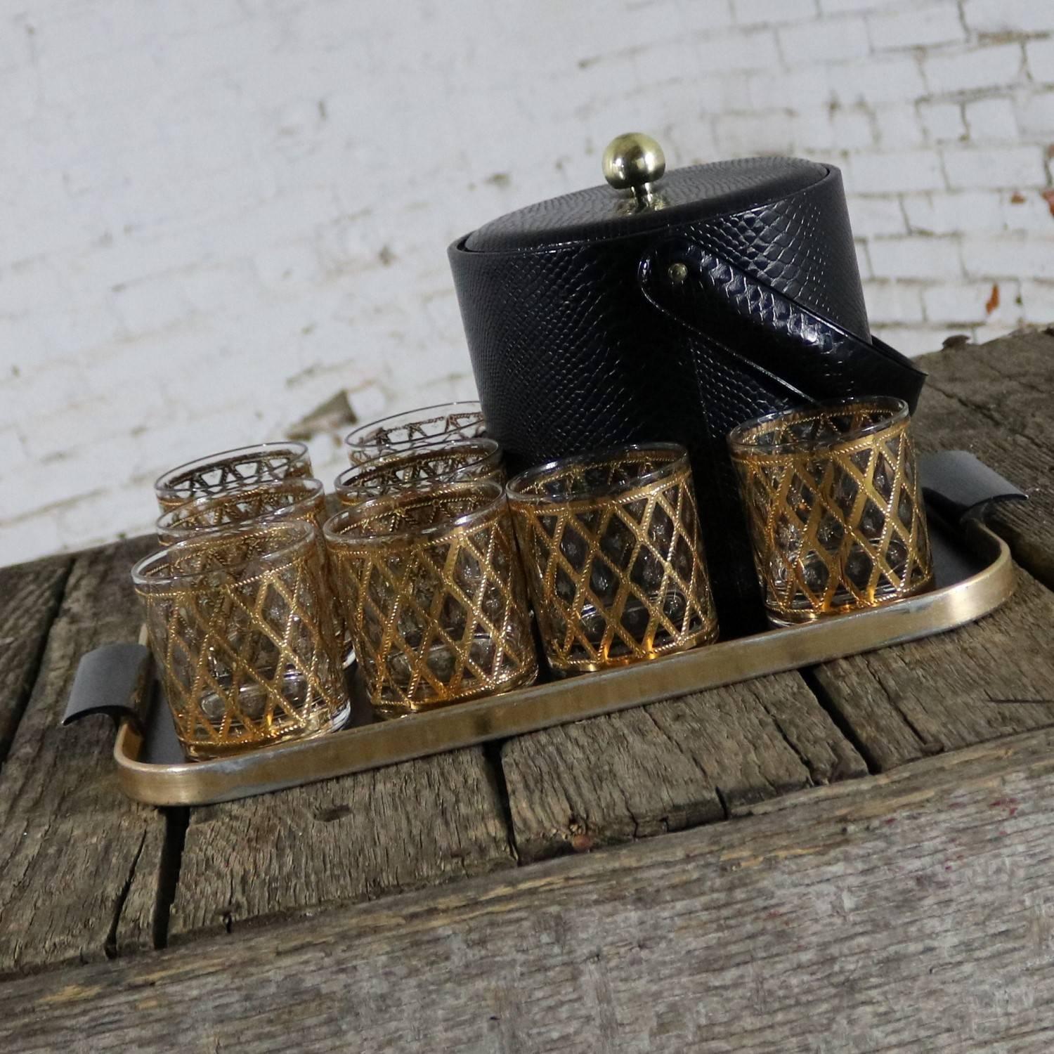Handsome and fabulous set consisting of a black and gold midcentury Georges Briard ice bucket, eight Culver old fashion cocktail glasses, and a black lacquered and gold colored aluminum tray. All are in wonderful vintage condition. The tray does