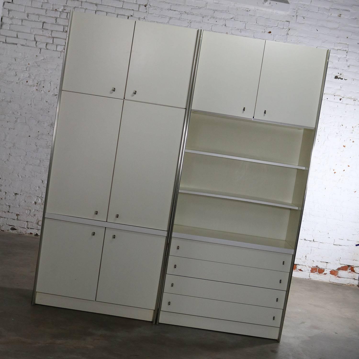 Handsome pair of Mid-Century Modern white laminate wall unit bookcase display cabinets. They do not retain their maker name and we have, yet, been unable to discover it. They are in good vintage condition with normal age-related nicks and scratches