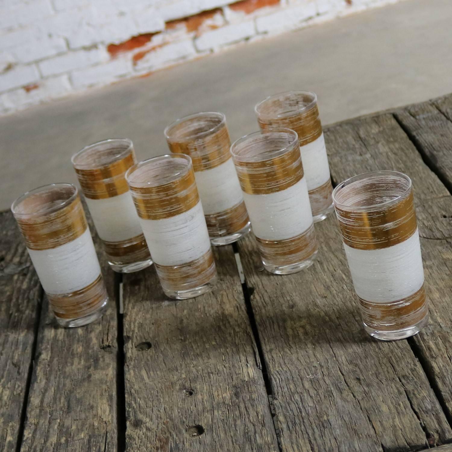 Handsome set of seven Mid-Century Modern highball cocktail glasses with alternating wide gold and white horizontal bands. In the manner of Culver Ltd. These are in great vintage condition with no chips, cracks or chiggers, circa