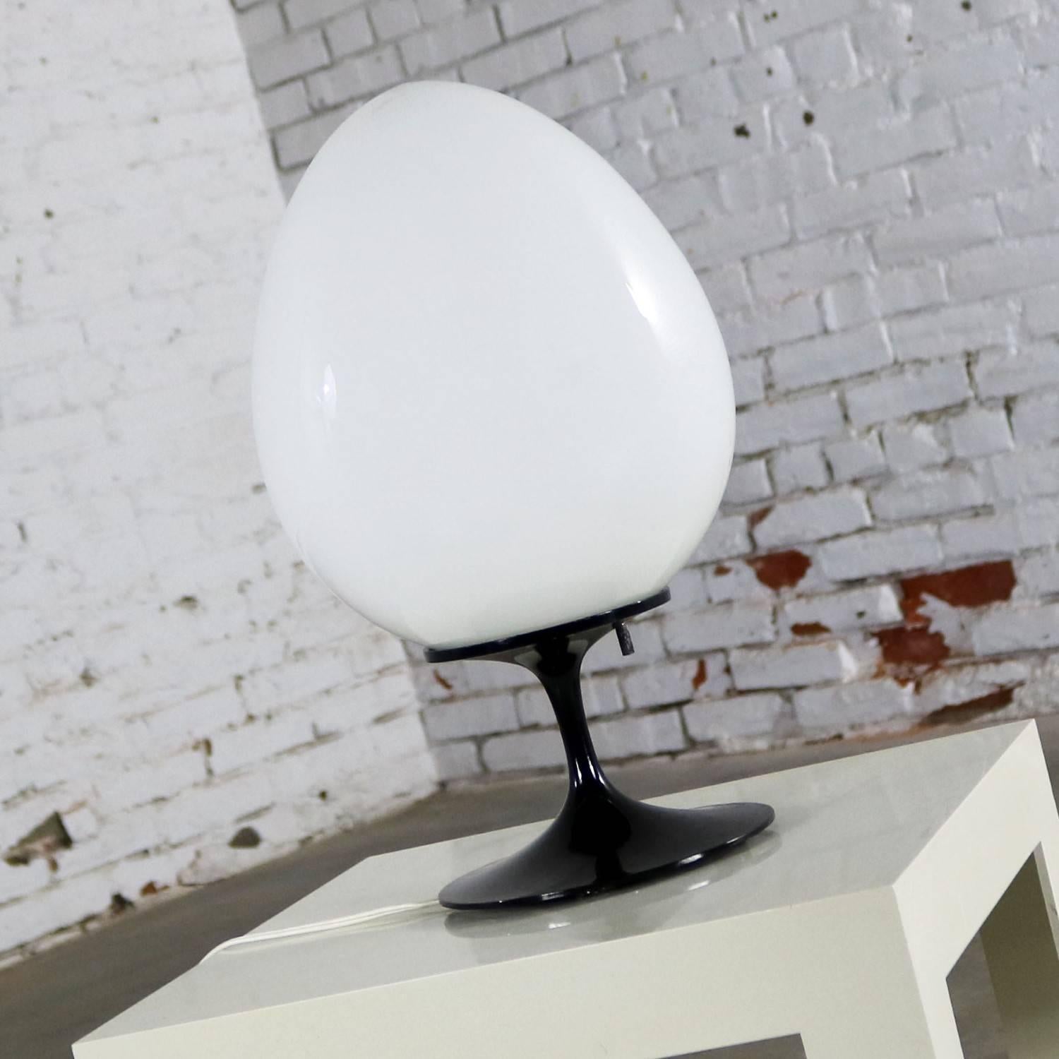 Fabulous circa 1960s Stemlite table lamp by Bill Curry for Design Line. This one’s tulip base is black, and it is sporting a white glass egg-shaped globe. It is in wonderful vintage working condition.

This incredible table lamp by Bill Curry is