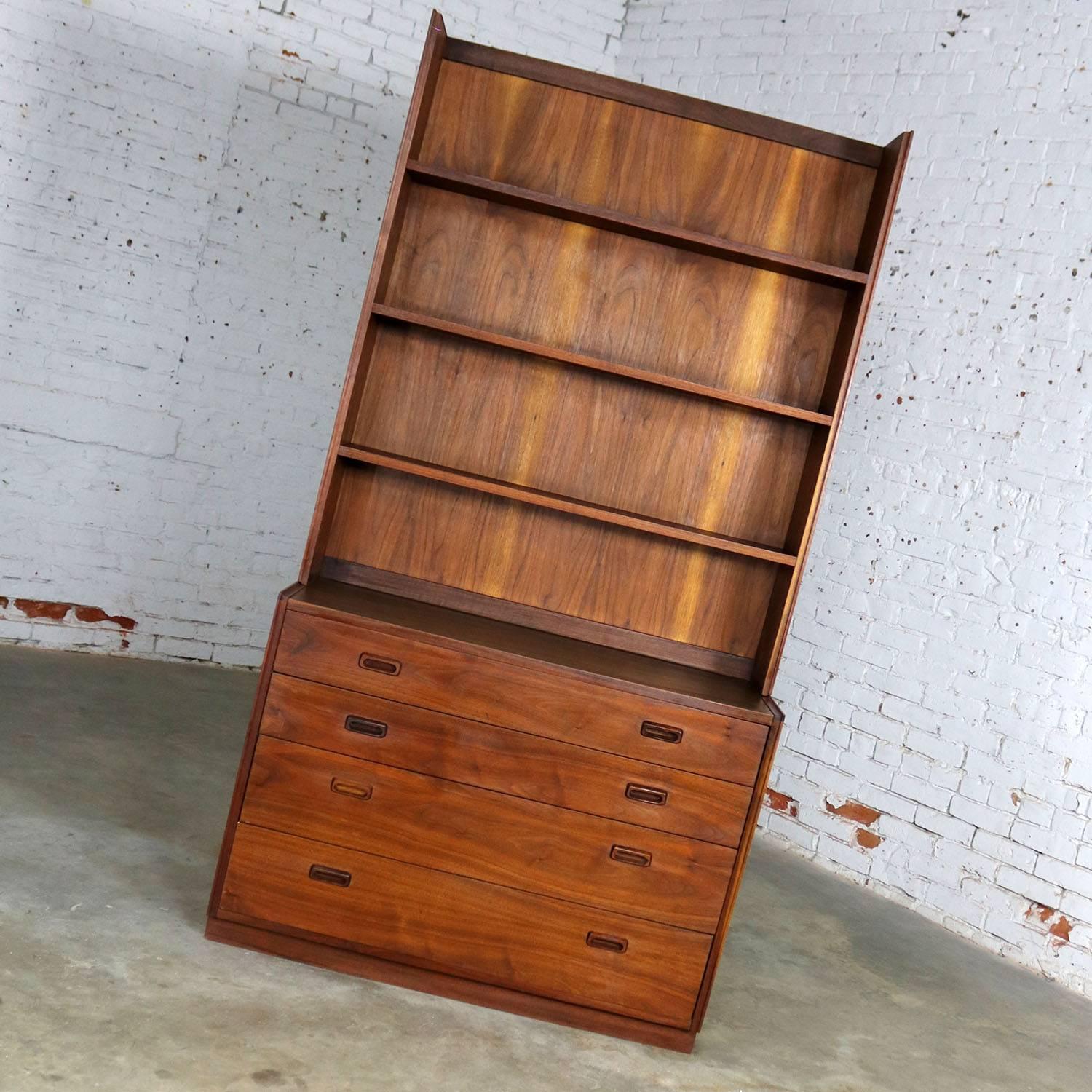 Handsome Mid-Century Modern two-piece bookcase or display cabinet which has been attributed to Founders Furniture. It is in wonderful vintage condition with no major flaws that we have seen apart from a chip in the wood on the upper side rail of the