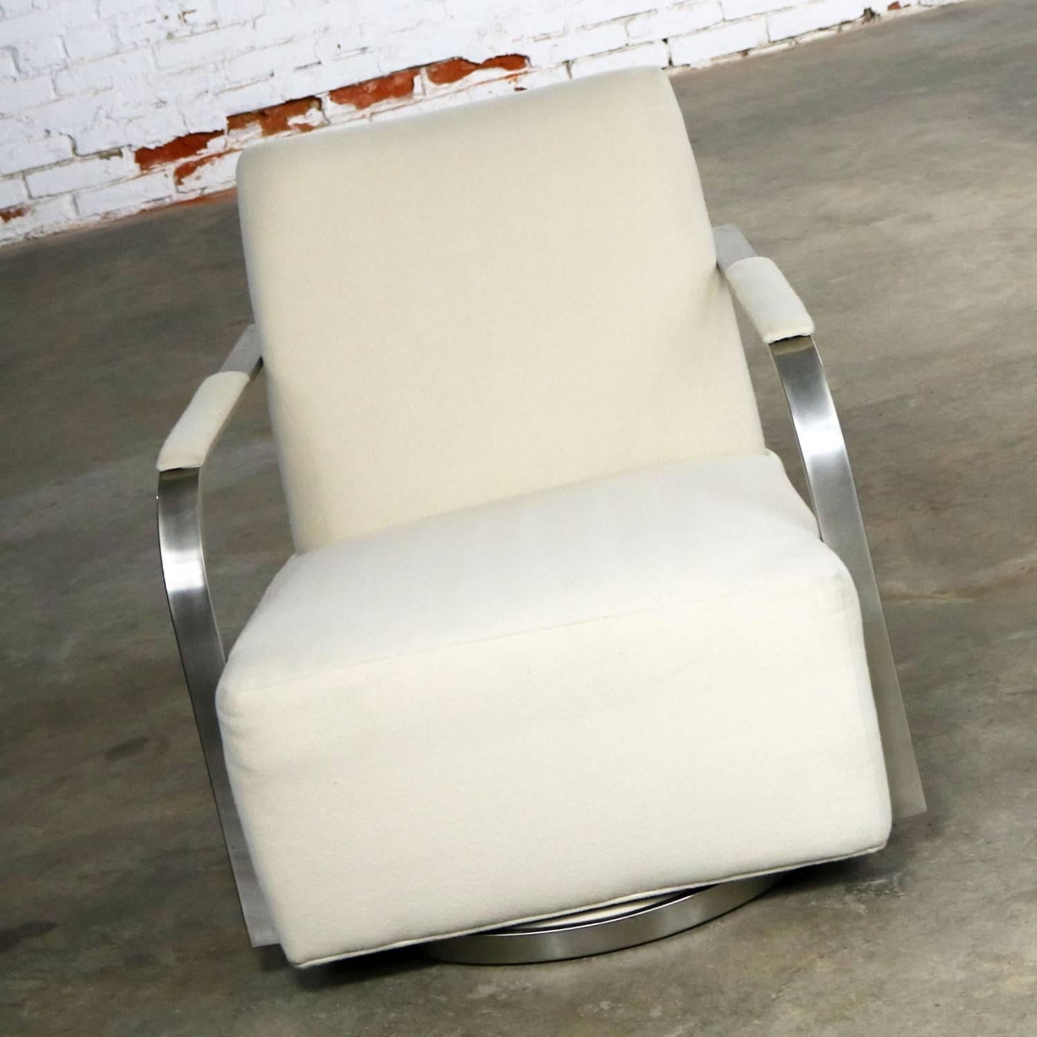 Wonderful 1086 Zac swivel lounge chair by Thayer Coggin in satin nickel and white wool-like fabric. This chair is recent production done in the style of Milo Baughman. It is in wonderful pre-owned condition, circa 21st century.

Handsome and done