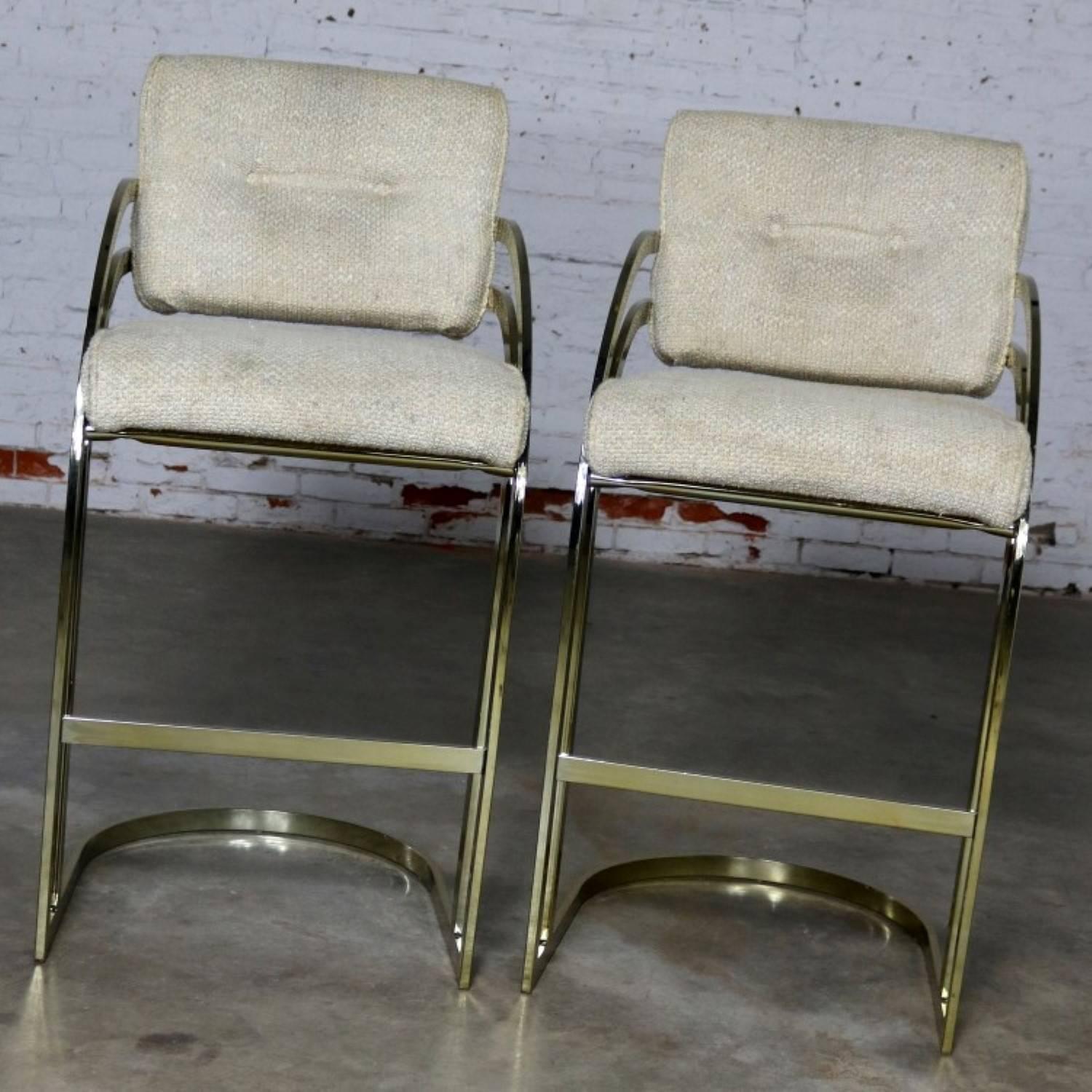 Wonderful pair of cantilever bar stools in the style of Milo Baughman for DIA. They are brass plated with upholstered seats and backs and in wonderful vintage condition. The brass plating is in great shape with minor scratching as you would expect