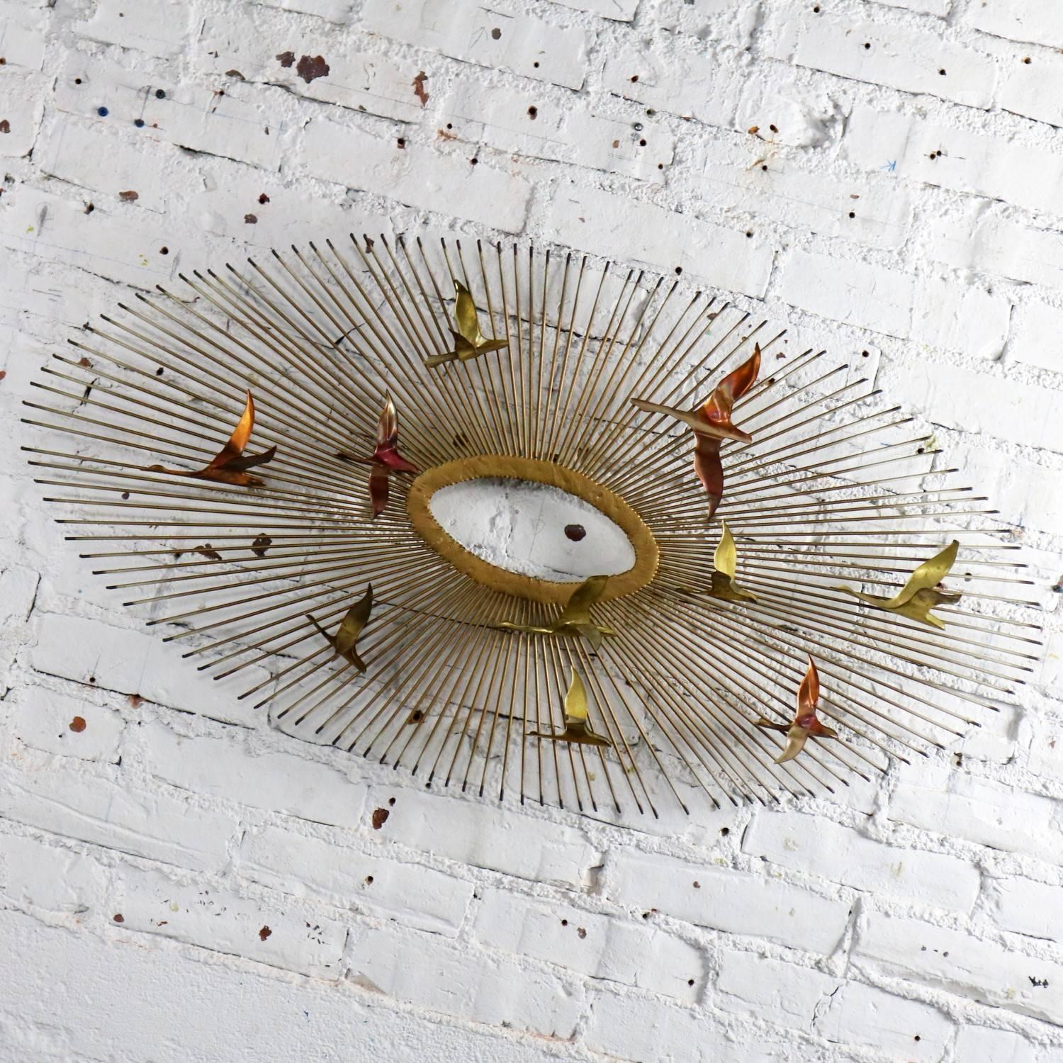 Handsome steel, copper and brass Mid-Century Modern wall sculpture depicting an oval sunburst with birds attributed to C. Jere; however, this one is unsigned. In wonderful vintage condition with no outstanding flaws, circa 1960s-1980s.

Not a