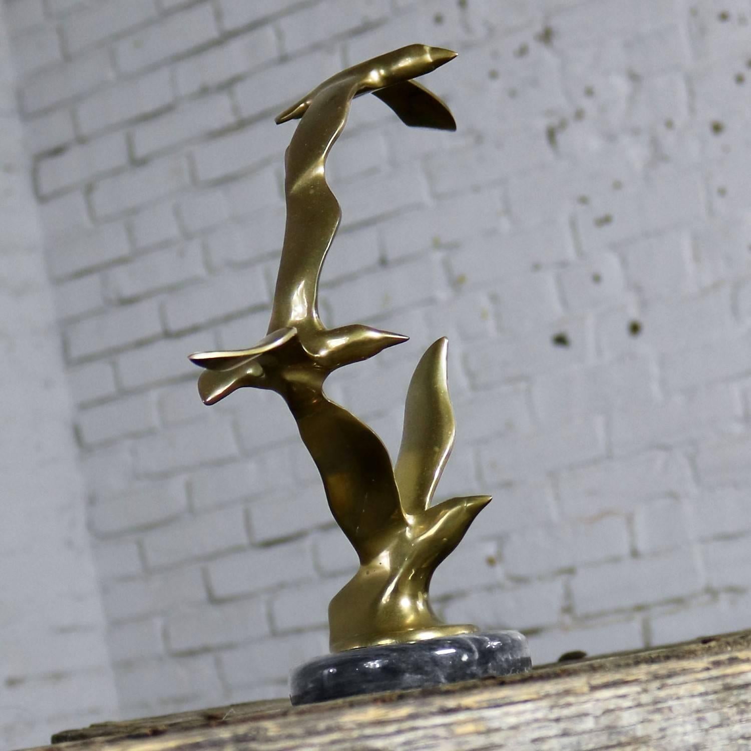 Mid-Century Modern drei Vögel im Flug Messing-Skulptur auf einem runden schwarzen Marmorsockel im Stil von C. Jere. Diese ist unsigniert. In gutem Vintage-Zustand, ca. 1960er-1980er Jahre.

Ein toller Möwenschwarm! Diese Skulptur aus Messing und