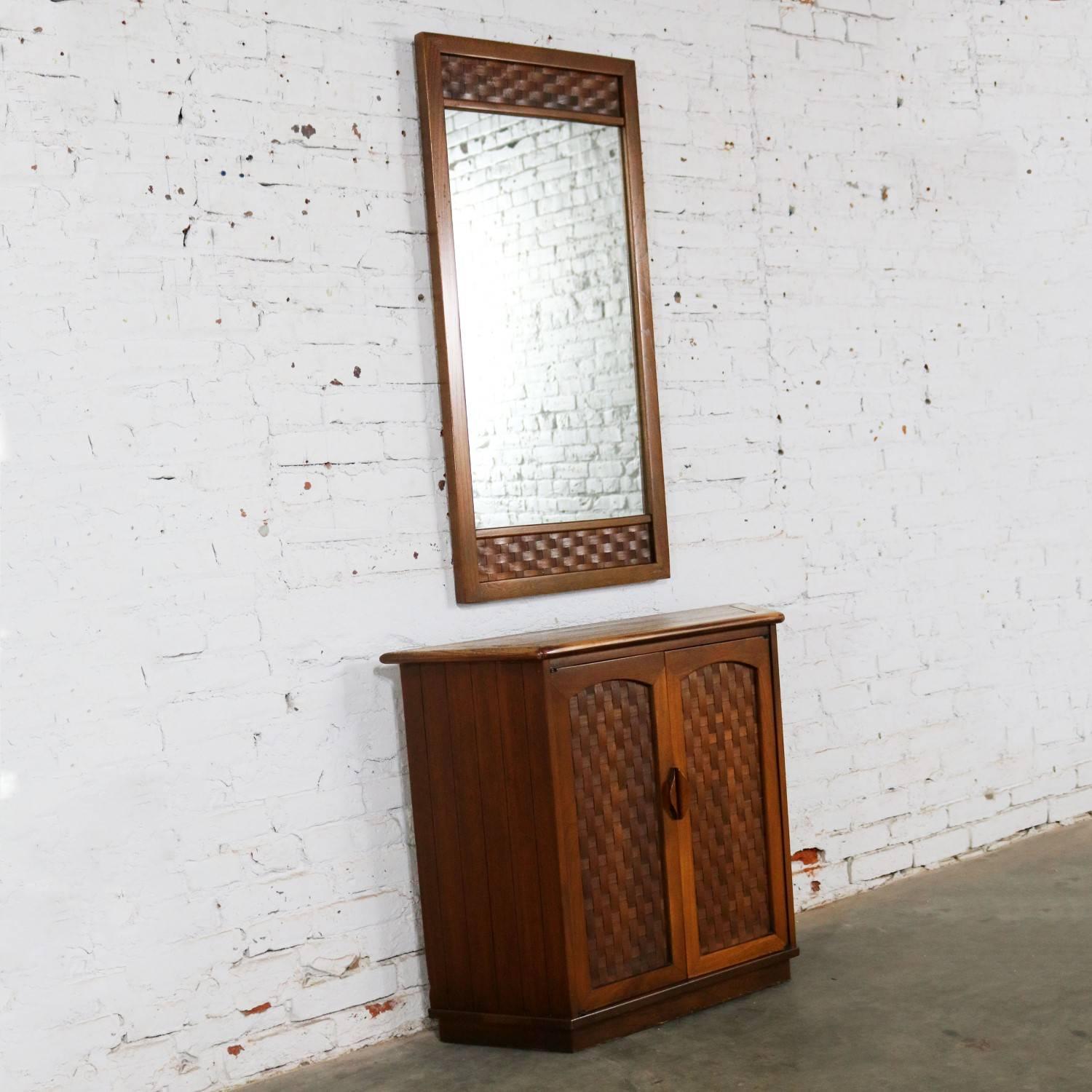 Handsome two-piece set comprised of an entry console cabinet and matching mirror with basket weave detail done in the style of Lane Furniture from their Perception line designed by Warren C. Church. These pieces do not have a Lane tag or mark. The