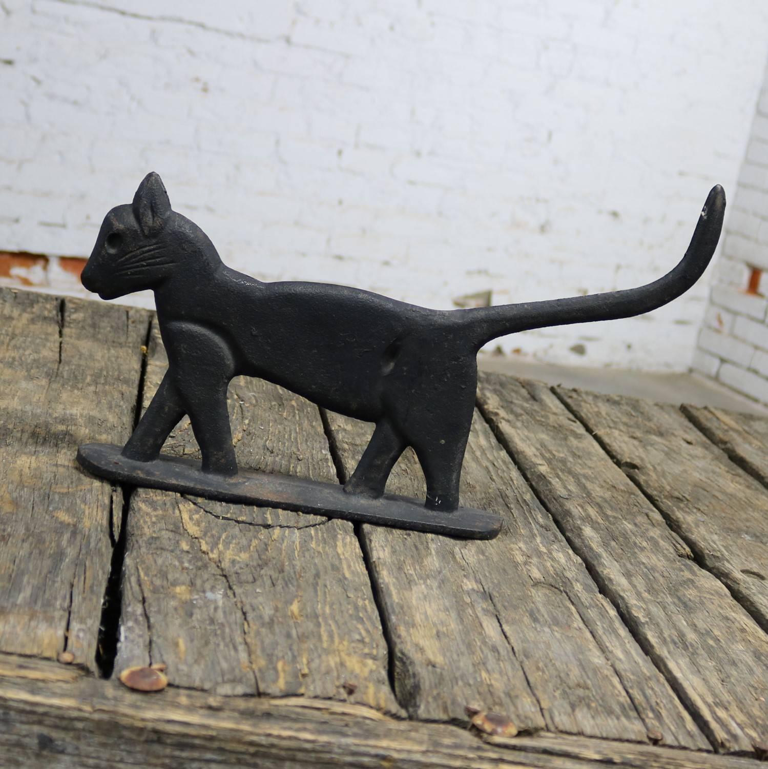 Antique and solid cast iron Folk Art black cat boot scraper or sculpture. Walking in Silhouette with tail held high and in wonderful antique condition with nice patina, circa 1900.

This guy is very proud and handsome whether you use him for his