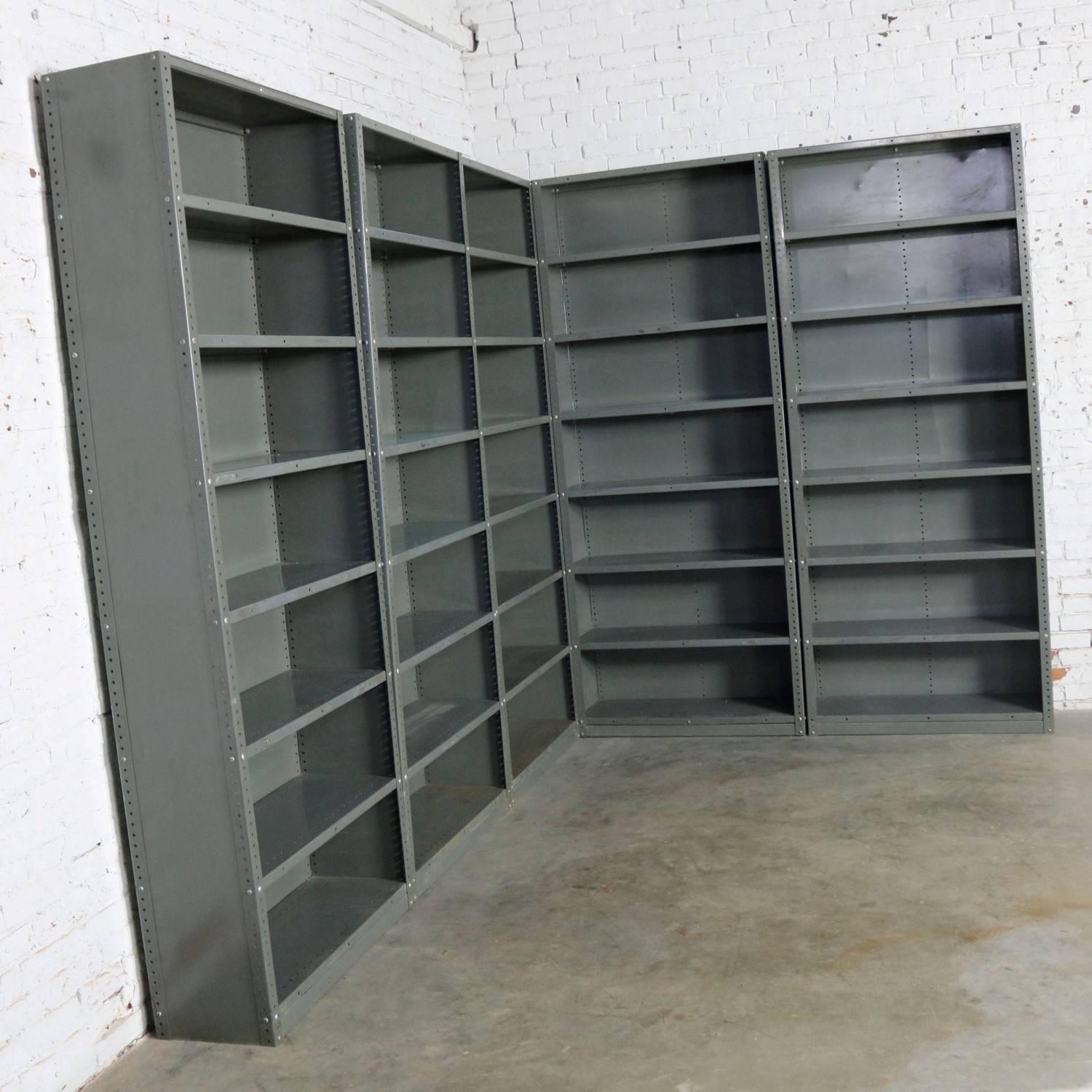 Awesome vintage industrial steel bookcase or shelving units. They are painted an industrial grey or green and have great age patina. All are in solid sturdy condition, but each have their own dings, dents, and bare spots that create a wonderful age