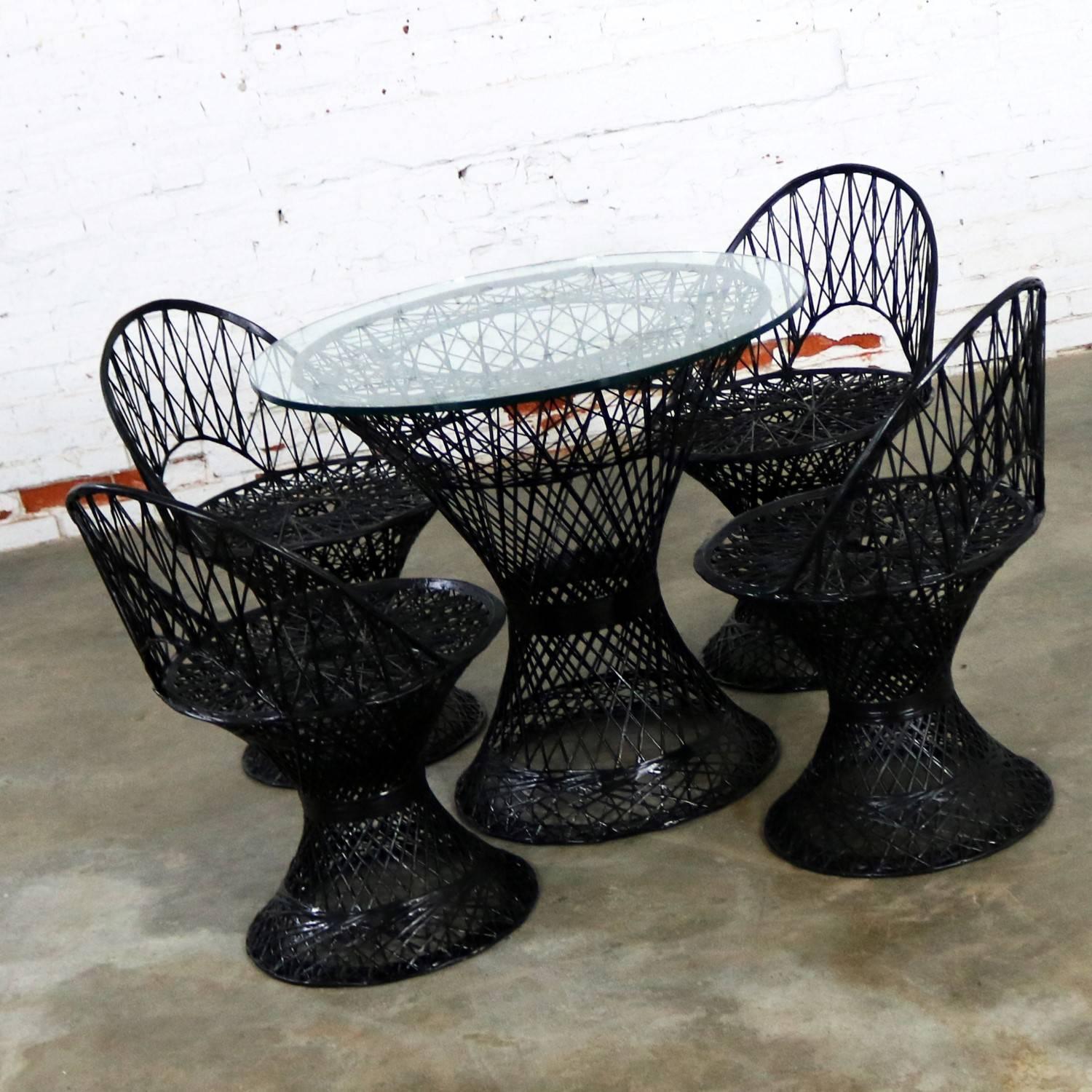Handsome outdoor spun fiberglass patio table and four chairs designed by Russell Woodard and produced by Woodard Furniture, circa 1960s. This set is very sturdy and has been freshly painted in black which is an attractive departure from the usual