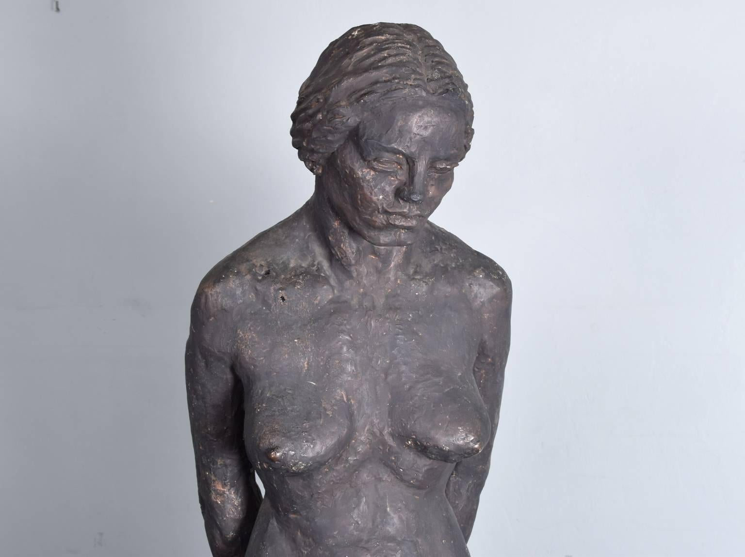 A well modelled female nude sculpture in cast plaster, dating from the second half of the 20th century. The original artist is unknown but the quality of the modelling is clear. The surface has been painted and shows signs of wear in places where