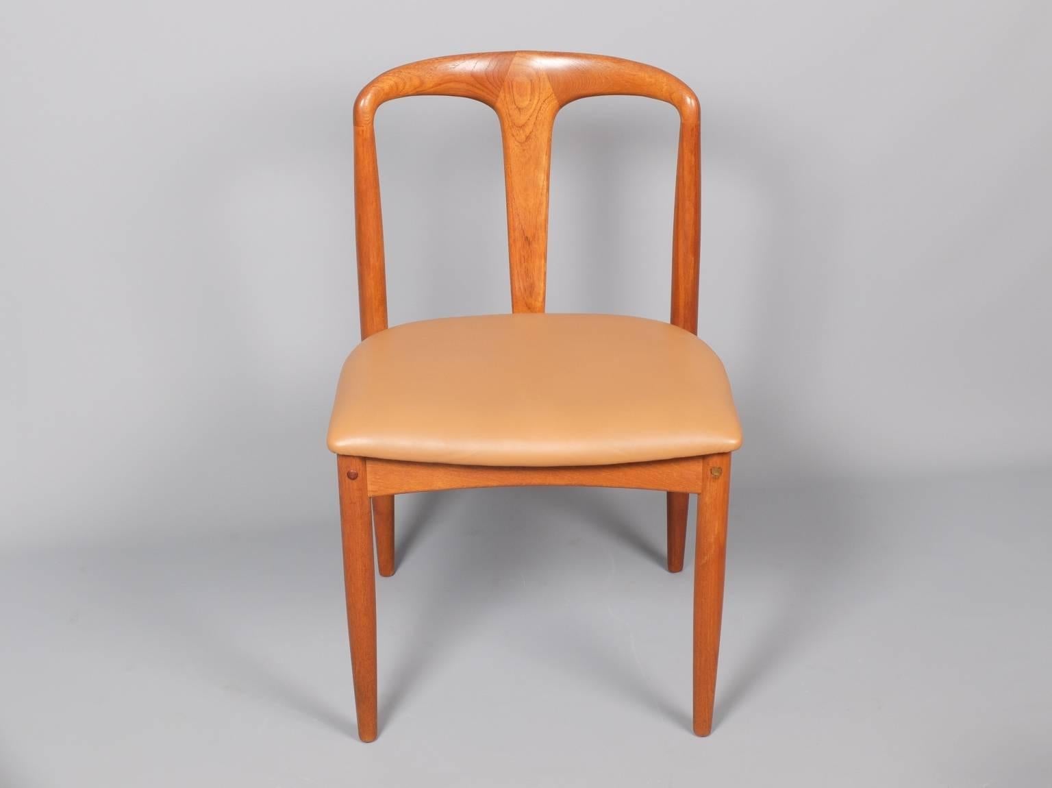 A set of six teak dining chairs, model 'Juliane,' designed by Johannes Andersen and produced by Uldum mobelfabrik, Denmark, circa 1960. The chairs are in excellent condition and the seats are covered in a cognac coloured soft leather. The teak