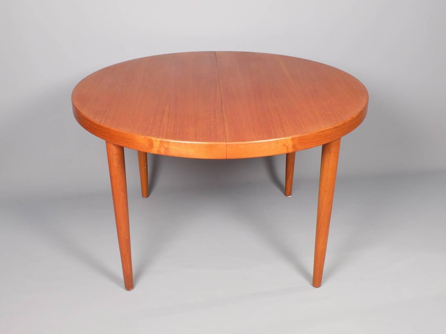 A teak dining table designed by Kai Kristiansen that features two inserts giving the option of three different lengths. As can be seen from the photos one of the leaves has the same rim as the fixed part of the table while the other does not and is