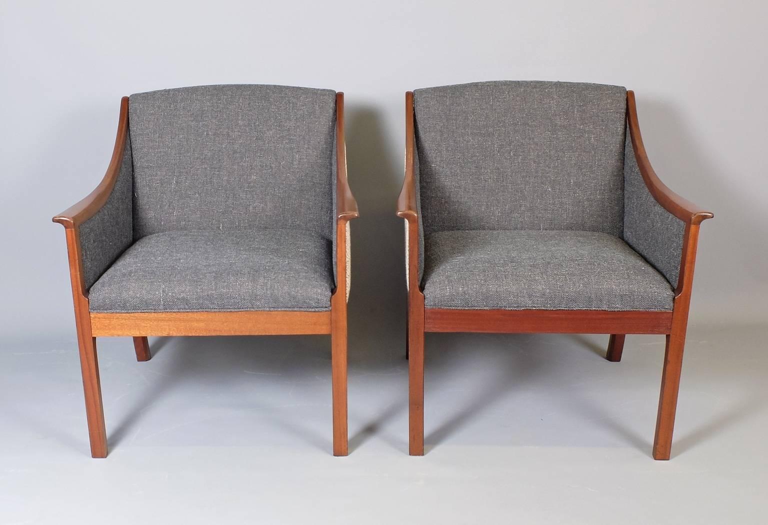 A pair of armchairs and matching sofa designed by Ole Wanscher and manufactured by Poul Jeppesen in Denmark in the 1950s. The elegant mahogany frames combine Wanscher's knowledge and appreciation of classical, antique furniture forms with a Danish