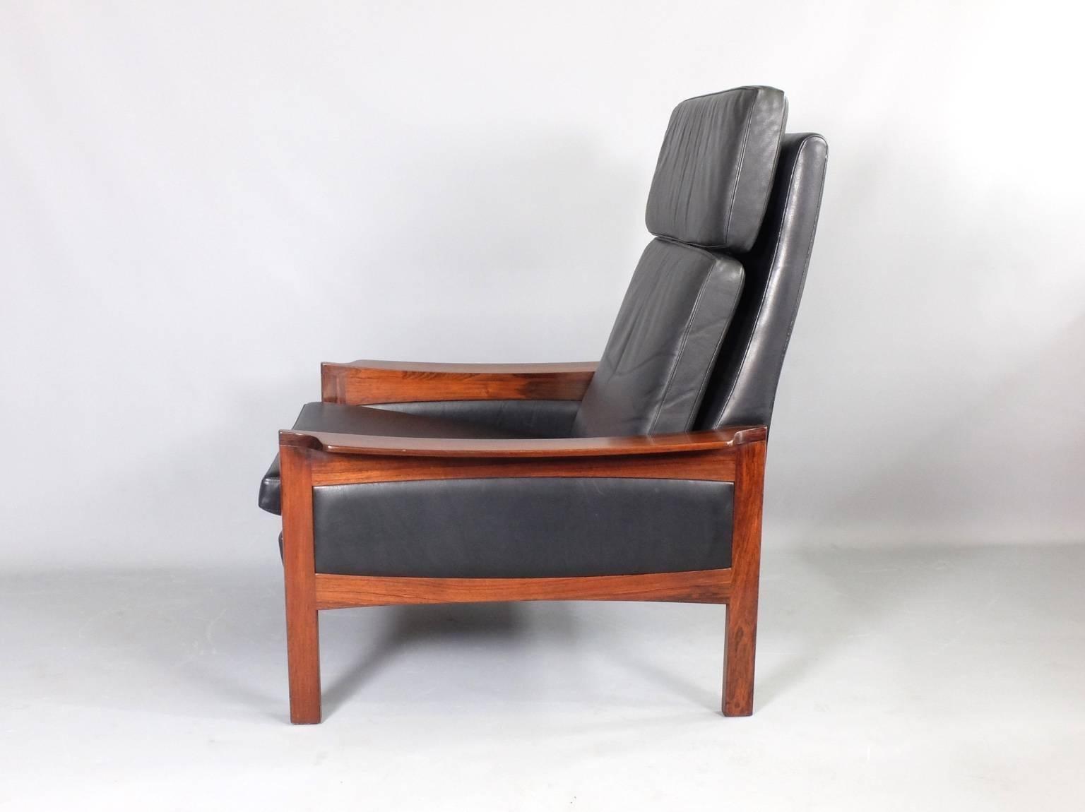 1960s Danish armchair with beautifully figured hardwood and black leather upholstery. A large, high back, comfortable lounge chair. The hardwood frame has been refurbished to bring out the full beauty of the timber. All the cushions have new