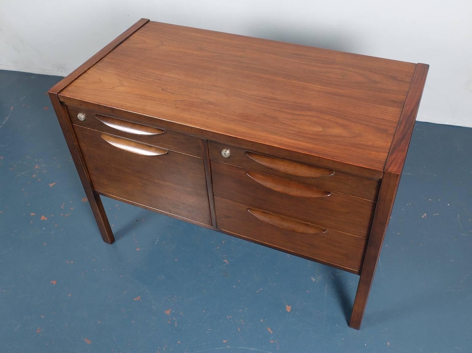 Designed by Jens Risom and produced in the United States by Jens Risom Design, circa 1960, this credenza is made of solid black walnut. The five drawers feature trademark Risom curved handles, also in walnut, while the ends have a simple but