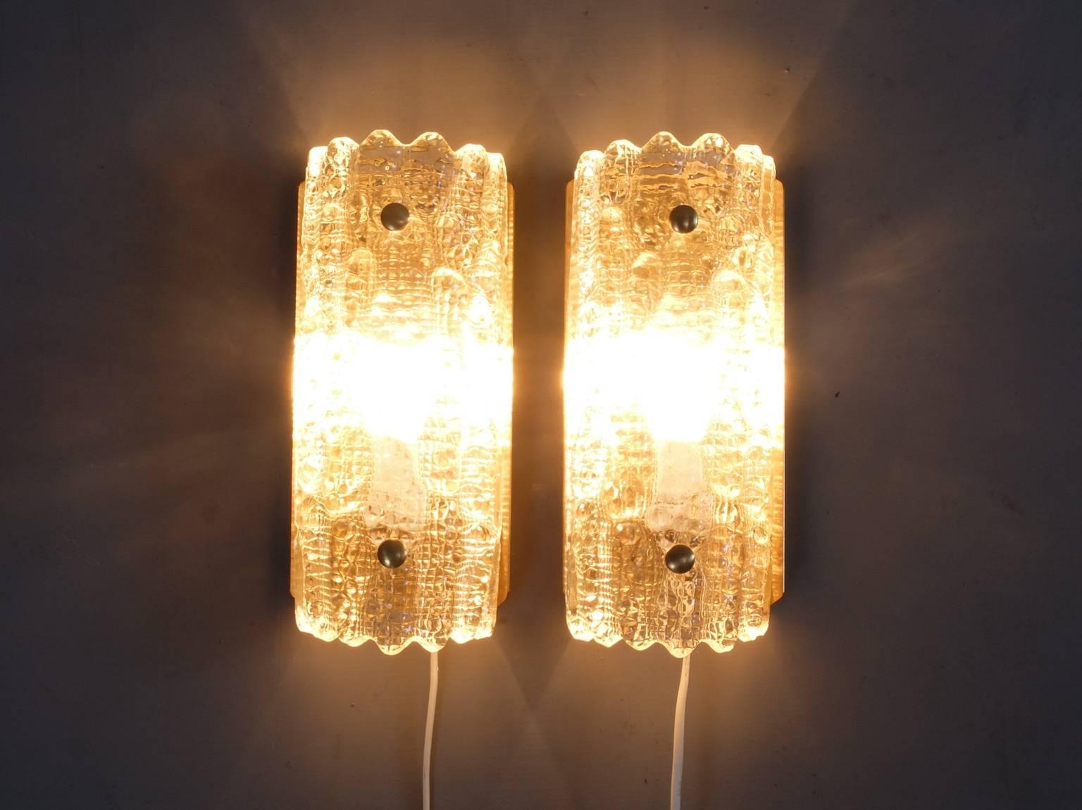 A pair of beautiful wall lights or sconces designed by Carl Fagerlund and manufactured by Danish lighting company Lyfa in the 1960s. The textured glass shades are by Swedish glass company Orrefors and are without chips or cracks. The glass is