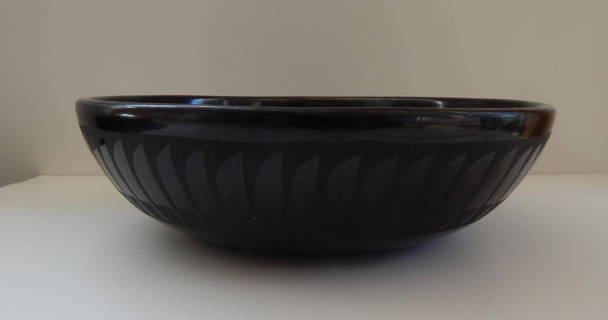 Large blackware bowl decorated with stylized feather design.
Signed “Marie & Santana” on the bottom.
One small flake on the rim 11.25