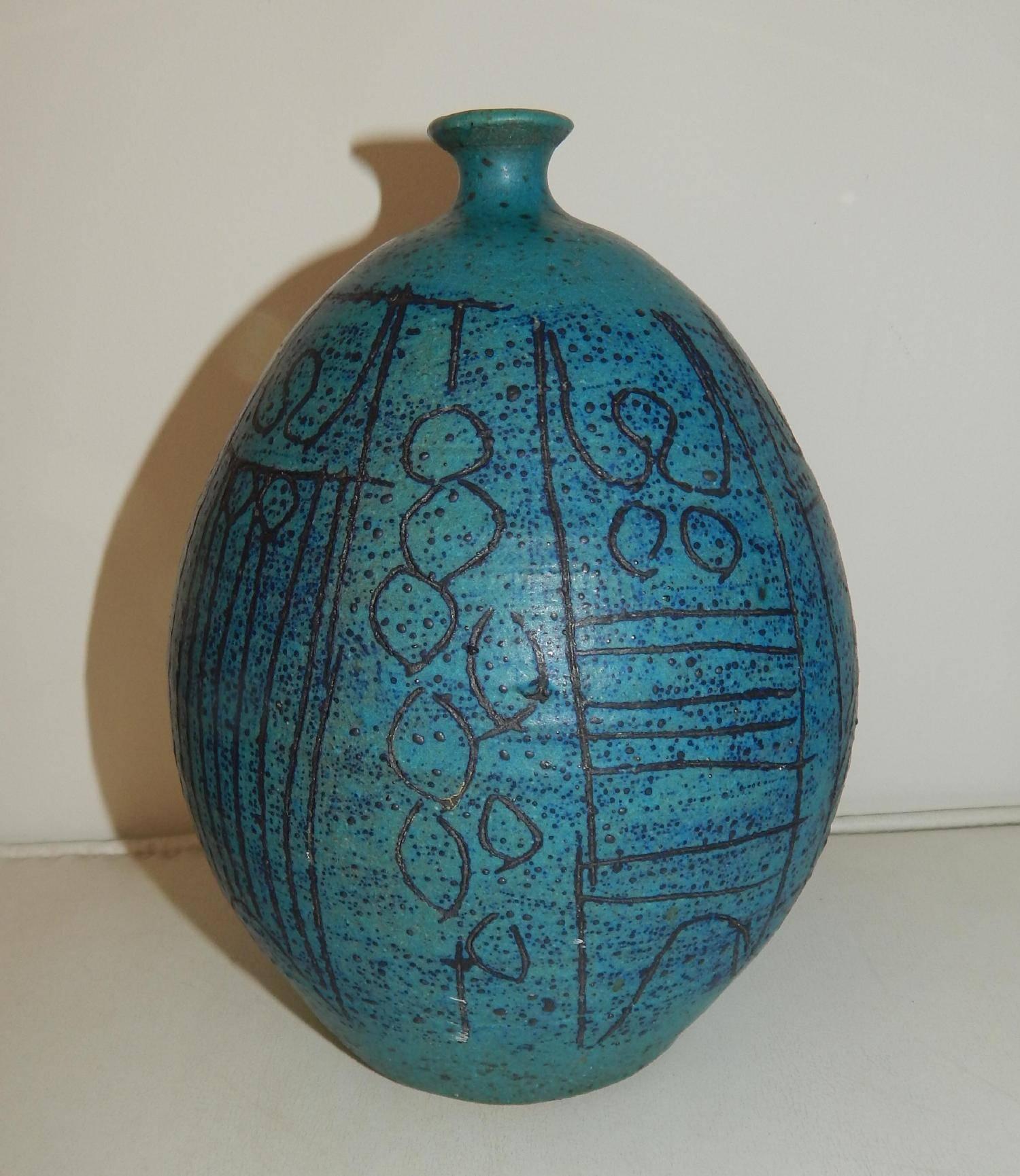 Blue stoneware bottle, wheel thrown, with modernist,
figurative sgraffito designs.
Marked: MKG.
By well-known designer and craftsman, Maurice K. Grossman,
from Tucson, Arizona who taught at the University there for many years.
Measures: 8
