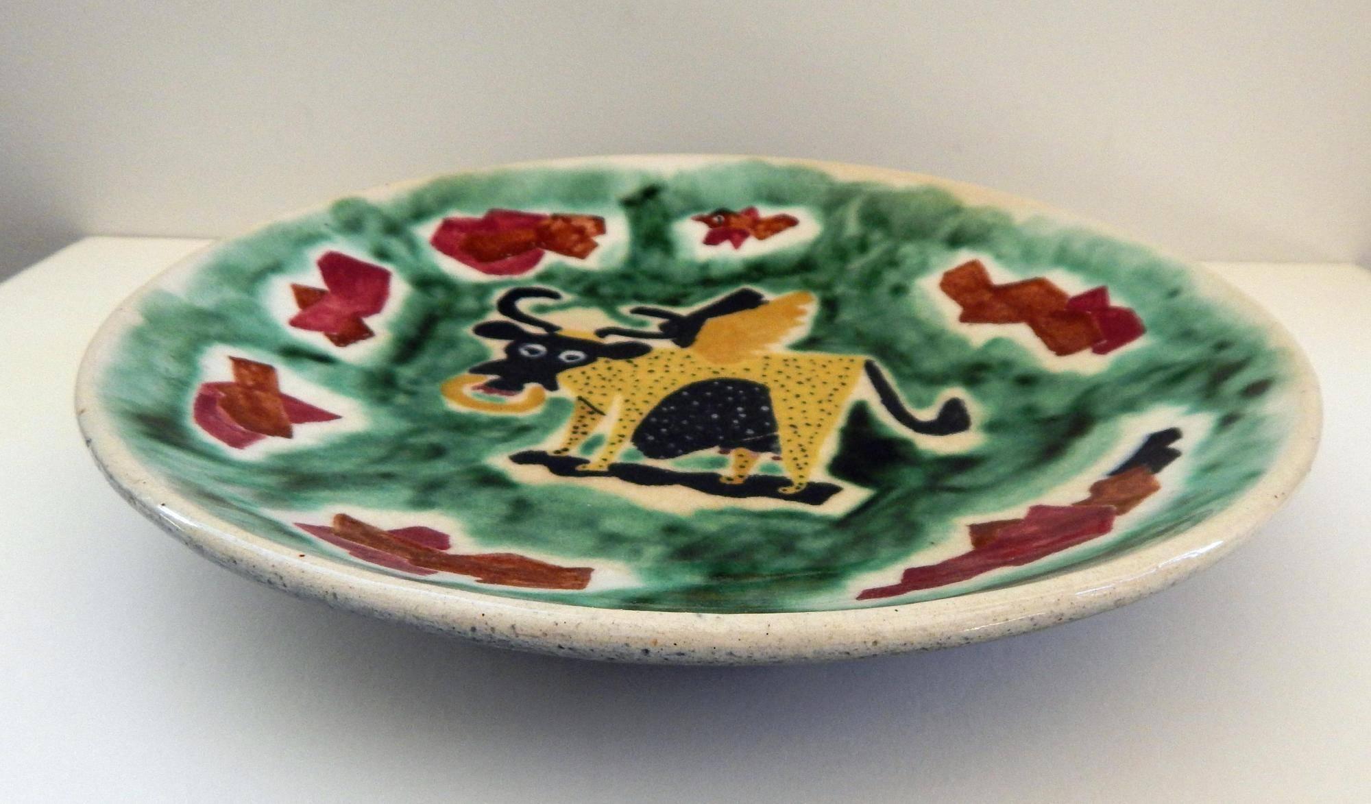 This whimsical hand decorated platter depicting a winged cow is in excellent condition.
Signed Nura on the front, AAA and SS on back
No chips, cracks or repairs. Measures: 1 7/8 H x 10 3/4 in D.

Nura Woodson Ulreich (1899-1950) was active or