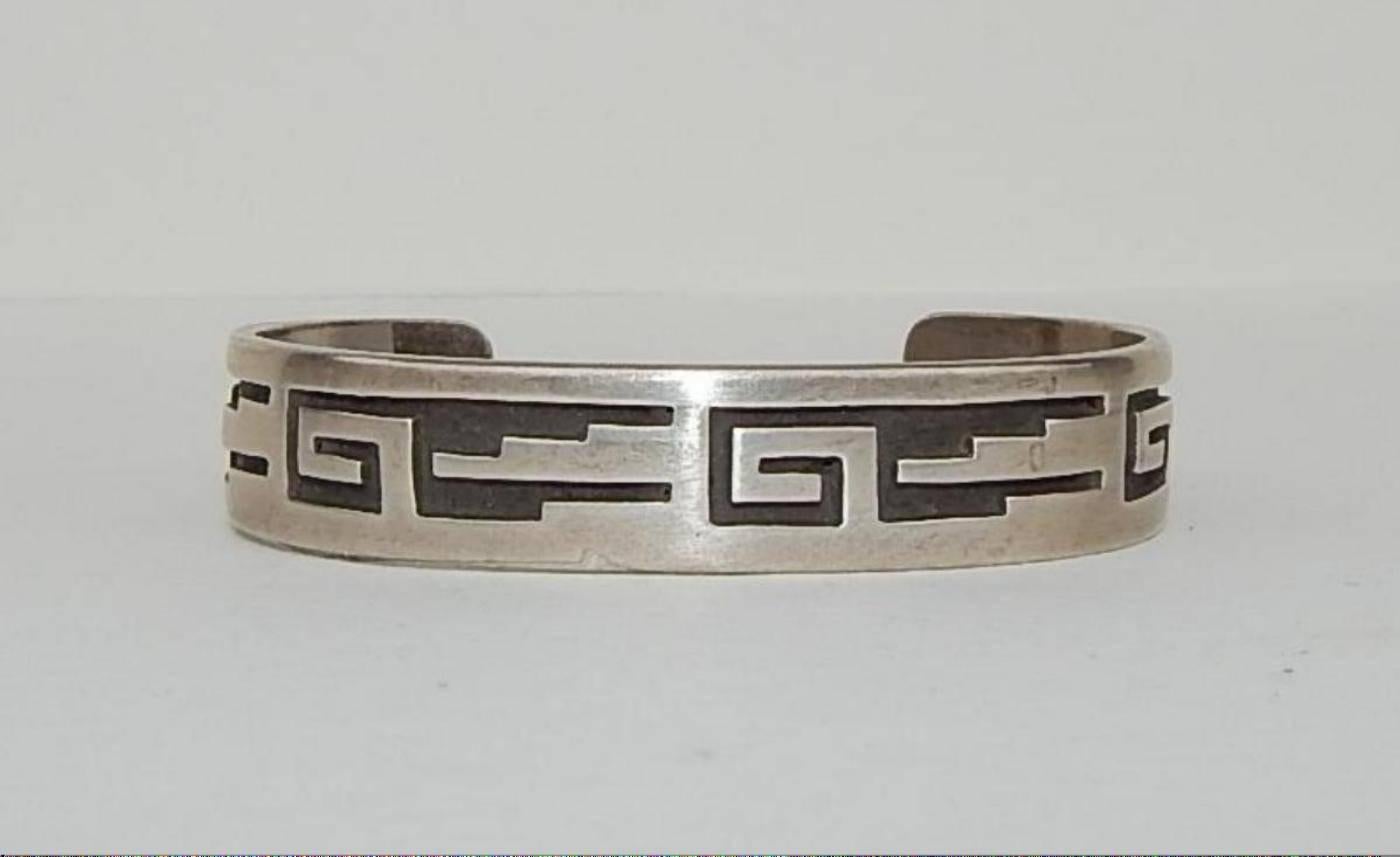 Beautiful sterling Bracelet in excellent condition crafted by
master Hopi silversmith Alfonso Gashwazra.
Incised monogram on the underside “H.A.G.”
Band is ½” wide.
Inside measures 2 ½ inches across and 2 inches deep
Fits 7-8