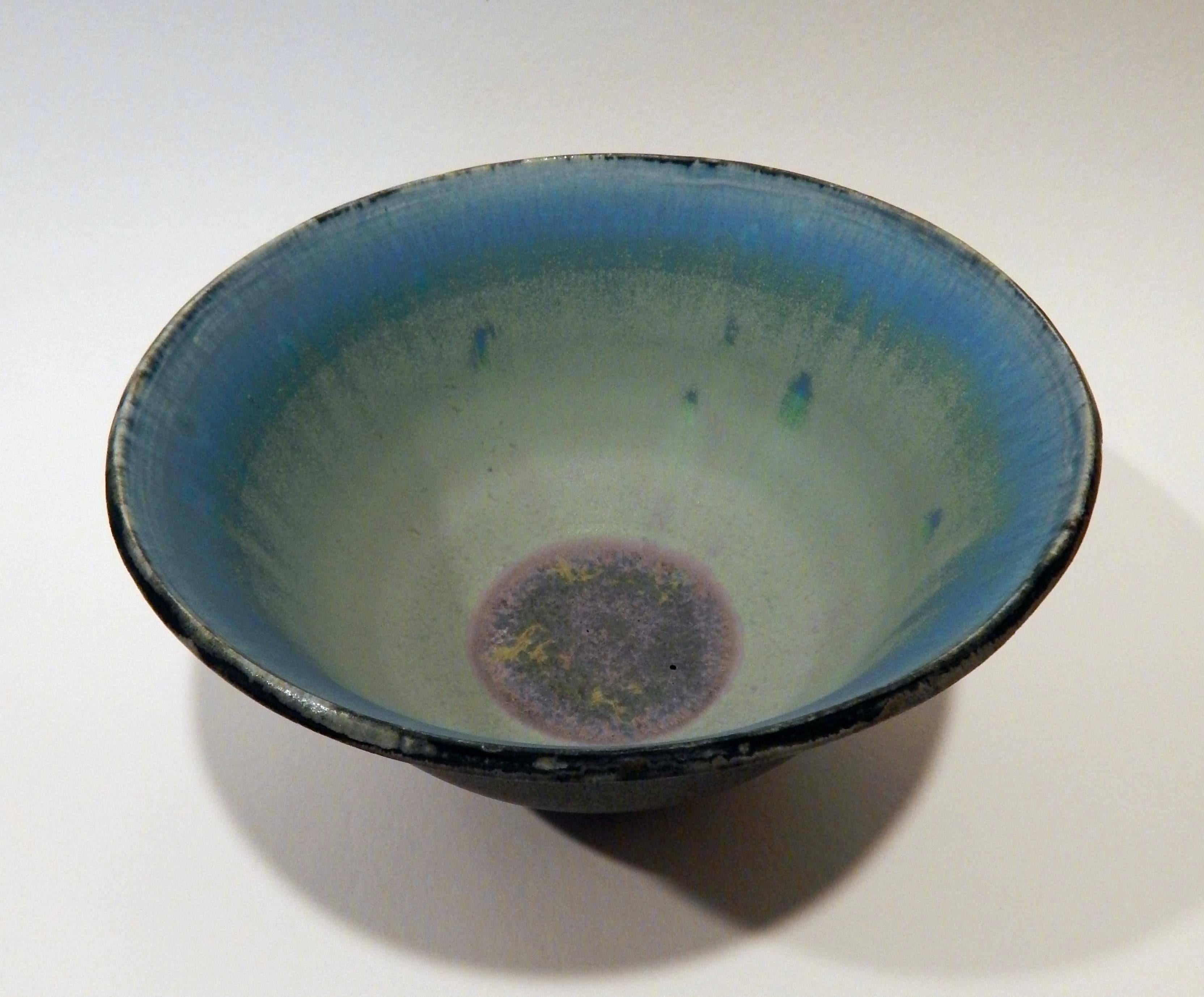 This rose Cabat flared ceramic bowl bears an
exterior glaze of bluish grey with
large drips showing near the base.
The interior glaze is two shades of turquoise
fading to a mauve centre.
Measures: 4.5