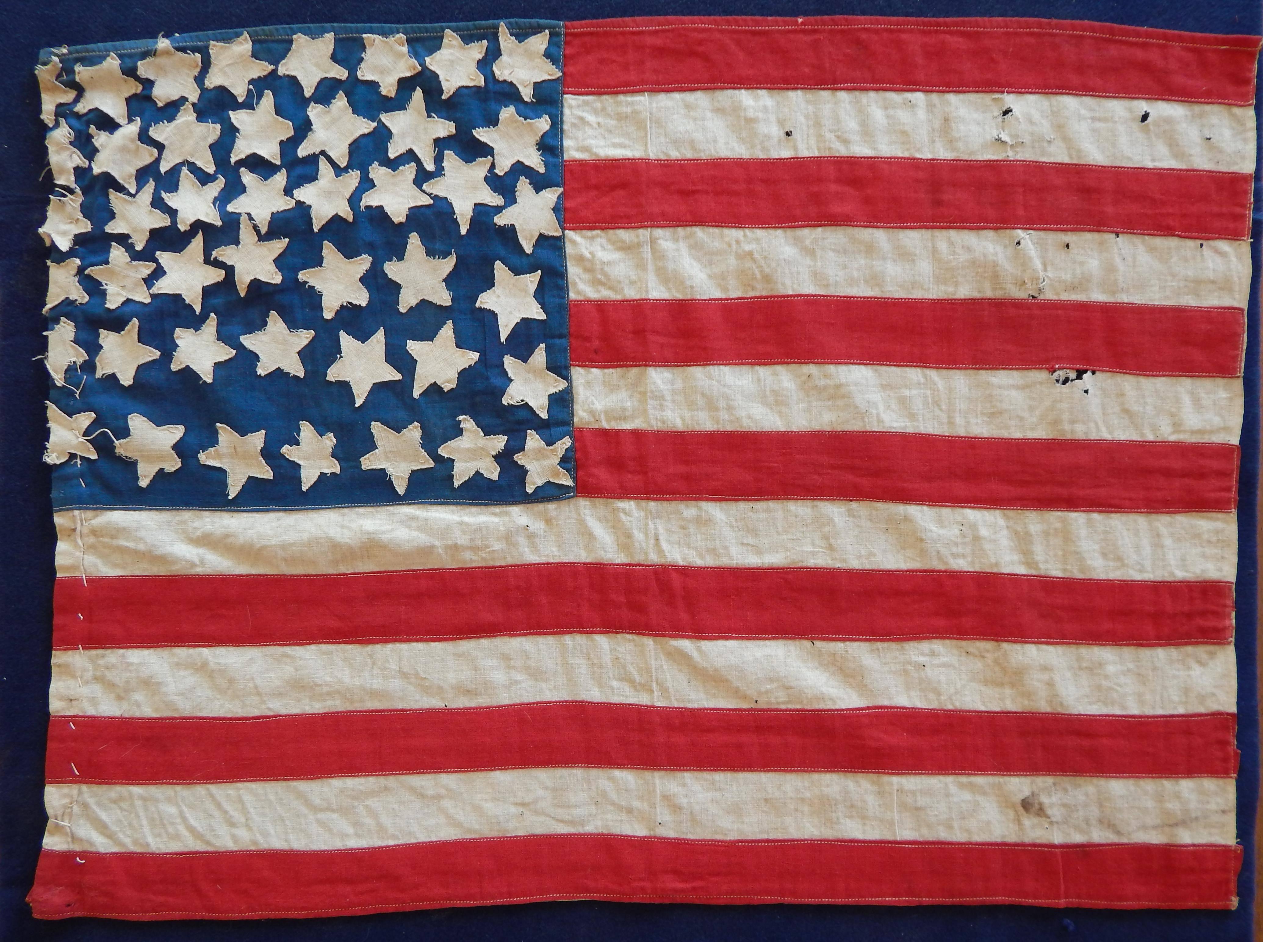 Wonderful bit of Americana.
Handmade Folk Art American flag with 44 Stars.
Hand-stitched edge and stars with machine stitched stripes,
circa 1890s
Our flag bore 44 stars beginning July 3, 1890 with the admission
of Wyoming till 1896 when Utah