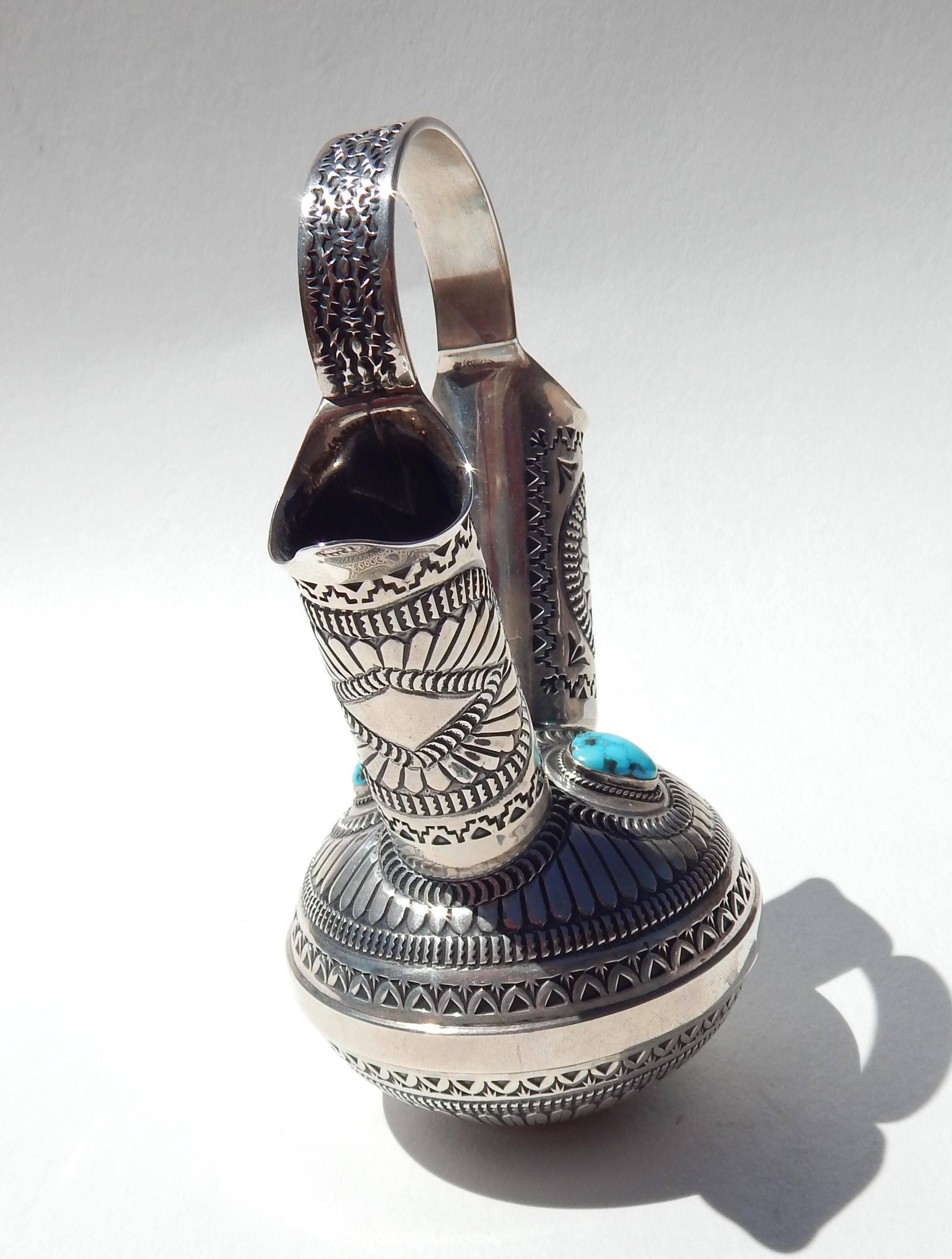 Beautiful hand stamped sterling vessel in the Navajo wedding vase style
by Native American Craftsman Sunshine Reeves.
Signed on the bottom “Sunshine Reeves” and marked sterling.
Decorated with a beautiful piece of turquoise on each side. 
In