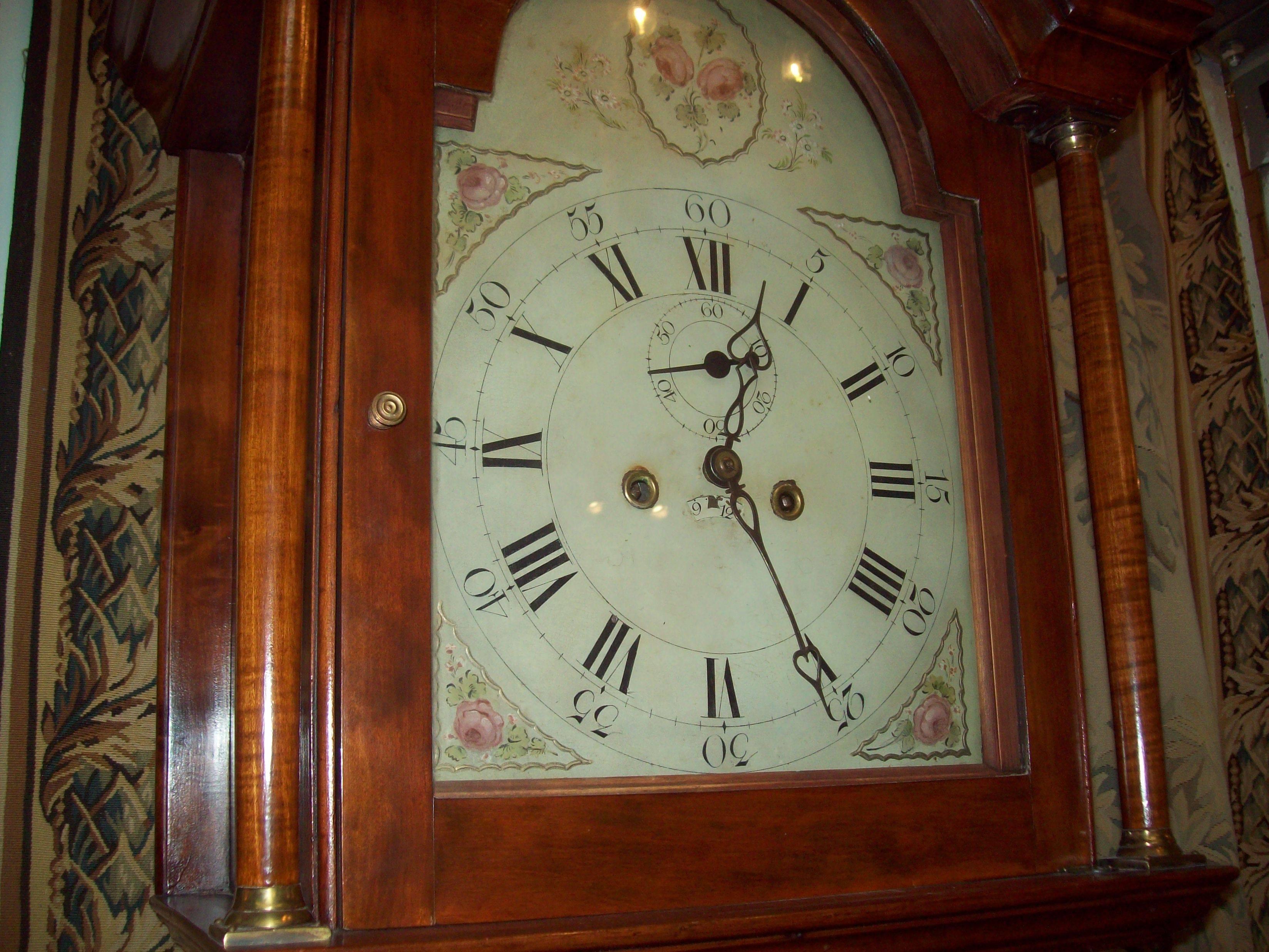 A tall, elegant American cherry 8-day longcase clock with reeded quarter columns and pierced fretwork cornice. Original painted face with no restoration. Original decorative brass fittings including finials (most unusual). Original weights and