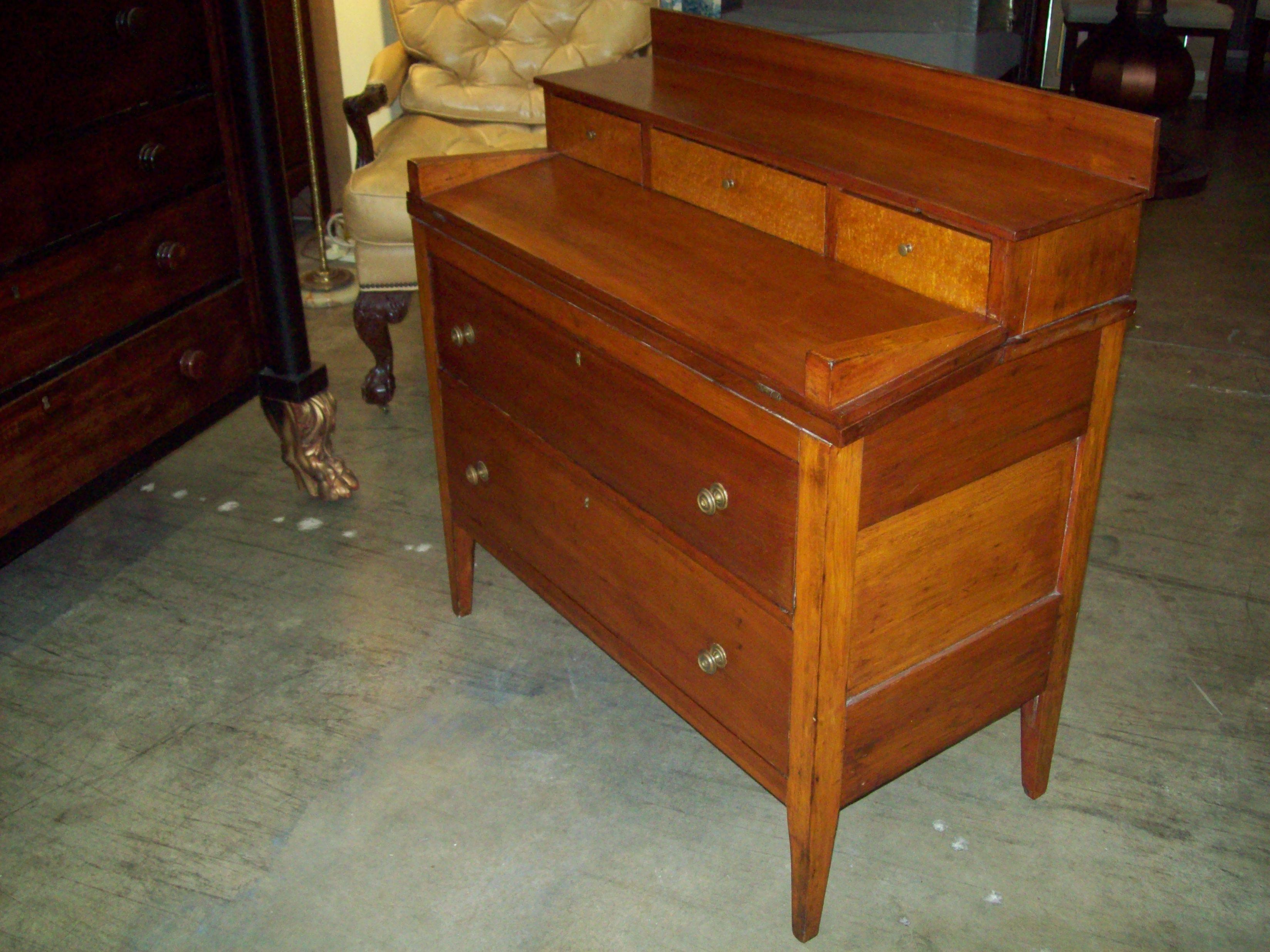 An American cherry drop-front desk in a characteristic country design in fully original condition. Well made with dovetailed drawers, intact legs and original locks and hardware. The small upper drawers are fronted in bird's-eye maple. Perfect for