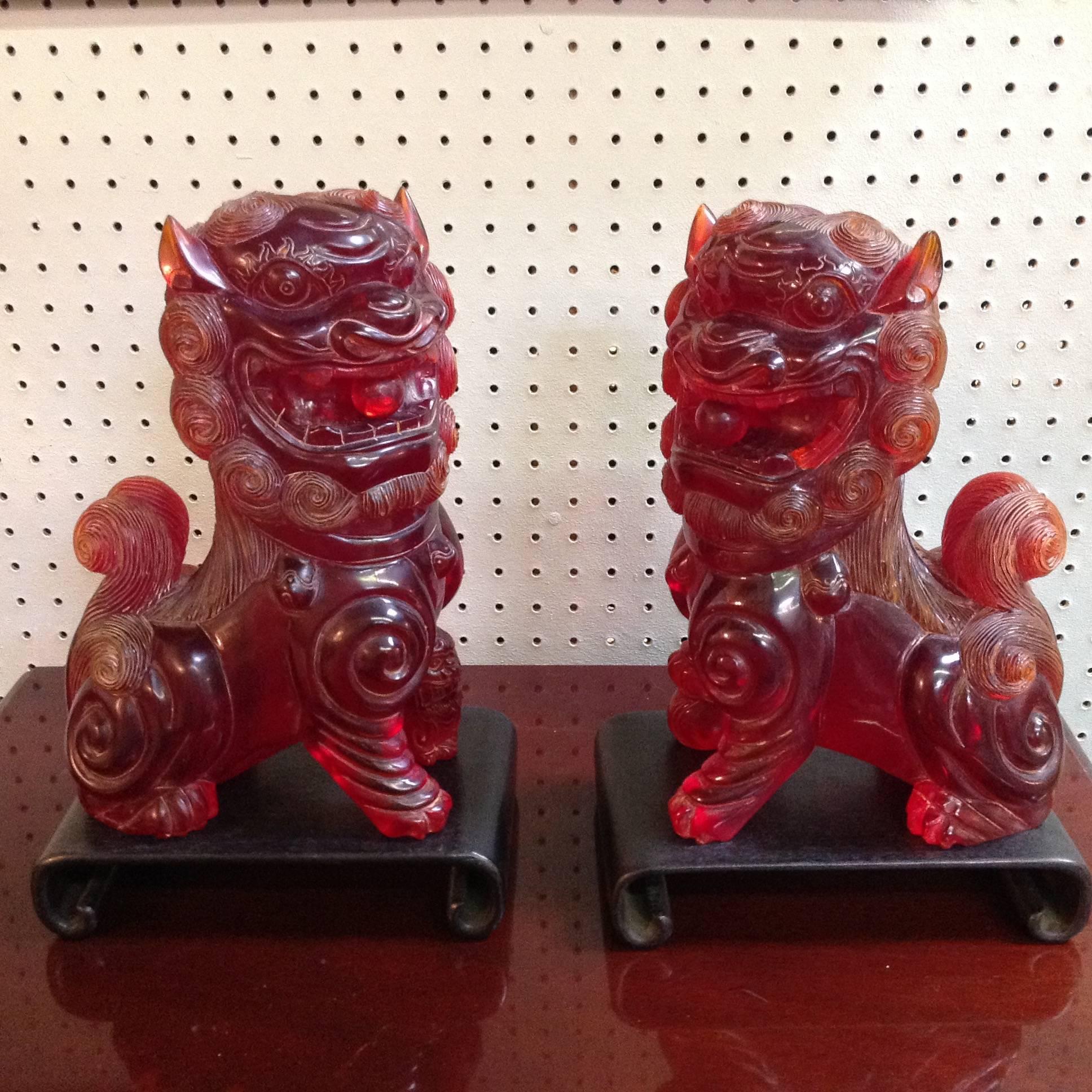 These reconstituted amber hand-carved foo lions were originally purchased at Gump's in San Francisco. The ball inside the mouth moves. These are exquisite and on scroll wood bases.