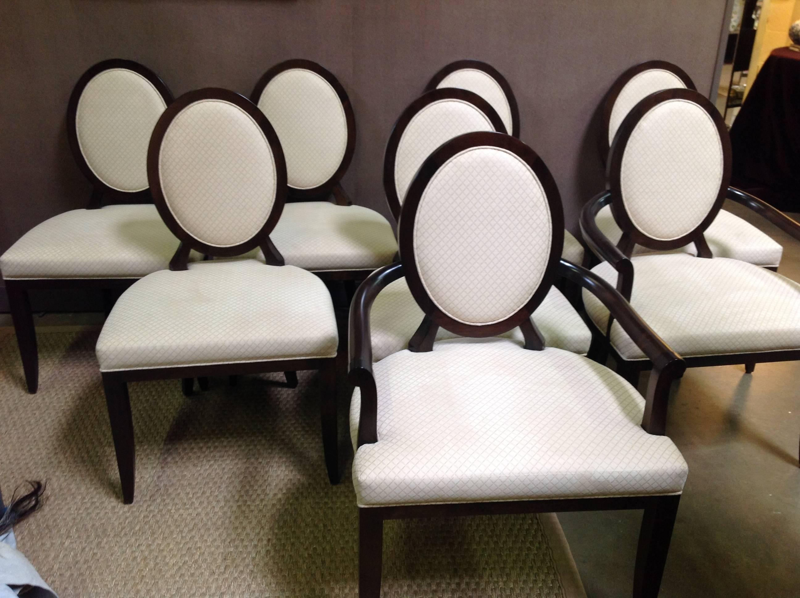 Bearing the signature Barbara Barry X -back these oval dining chairs feature a refined wood frame and inset upholstered back in java finish with x pattern cream velvet fabric. Set of eight (two arm, six side).
