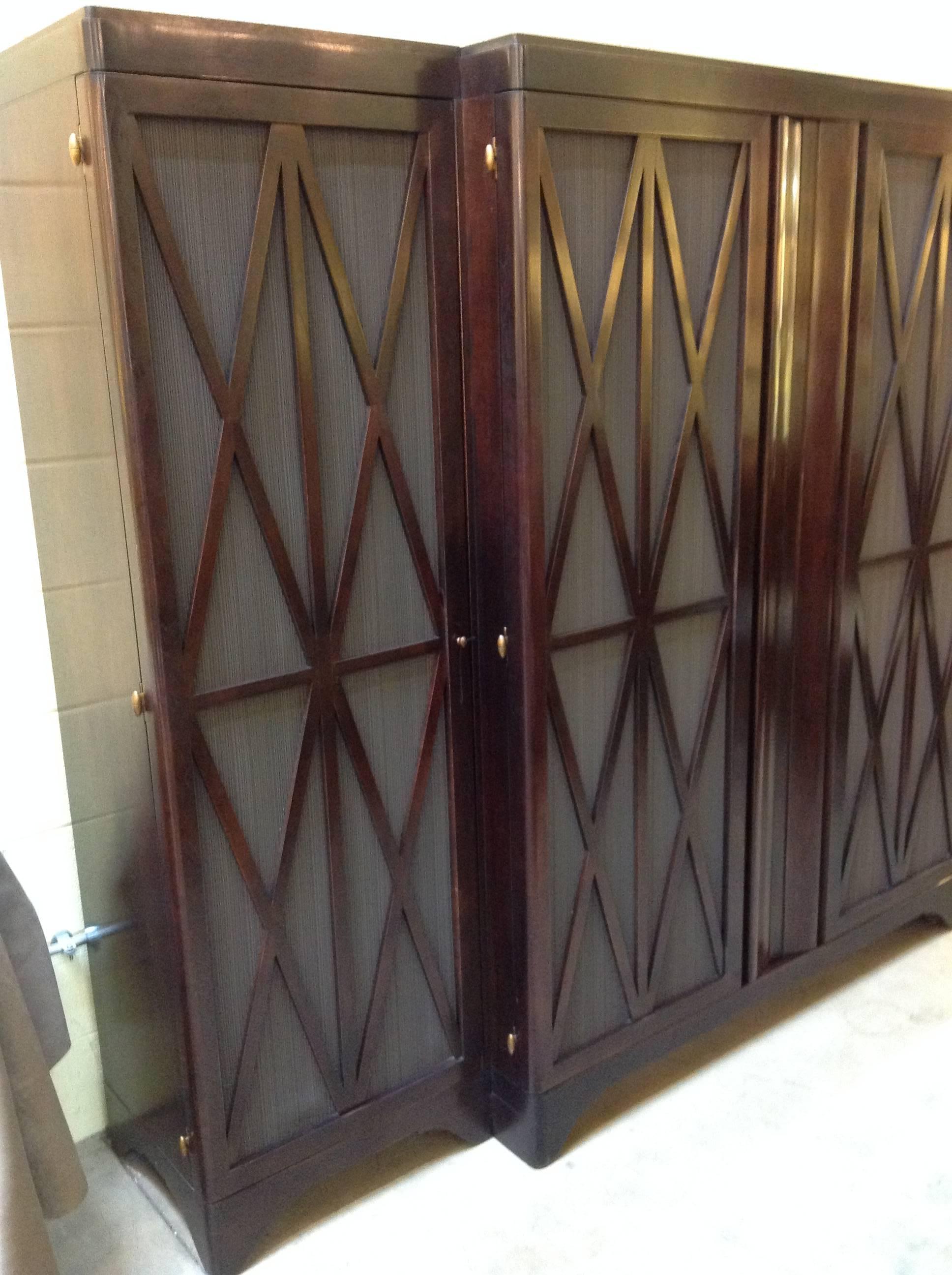 This Barbara Barry realized by Henredon Walnut Entertainment Center is in excellent condition and retailed for over $25k. The doors with x pattern design open all the way back for a clean sleek look and the material on the front doors allows sound