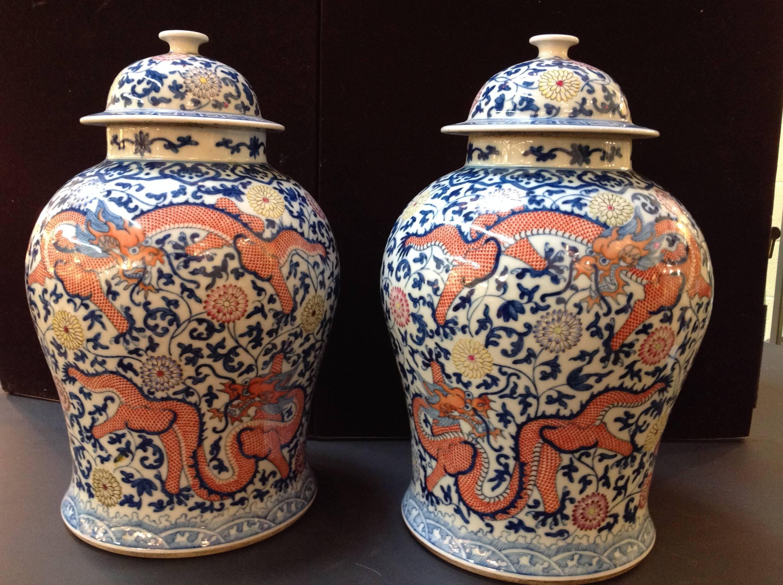 This gorgeous pair of antique temple jars from China are in mint condition and have orange dragons in two poses along with beautiful yellow, aubergene and two shades of blue flowers.