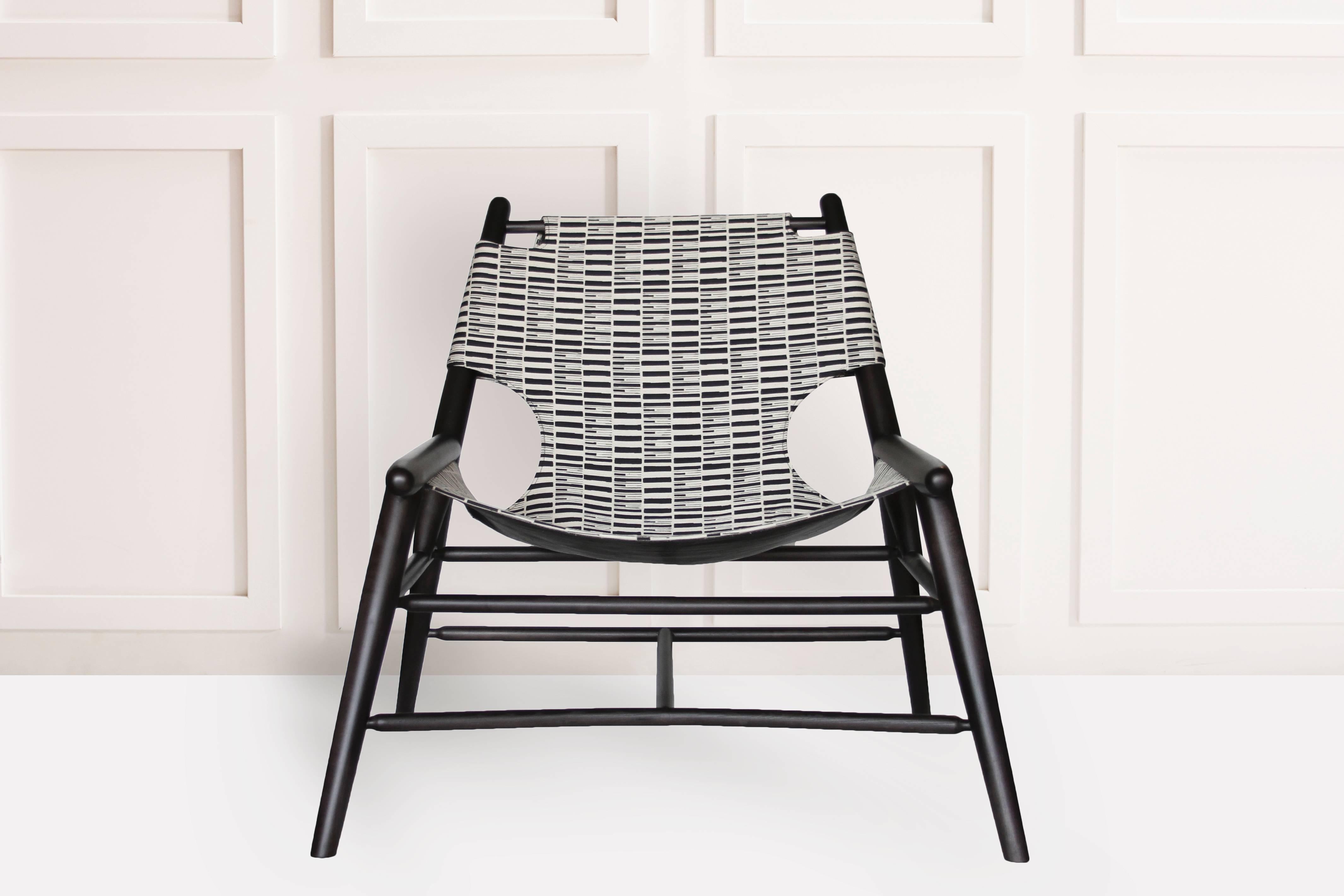 Made from maple and stained a rich black the sling chair may be upholstered in selections from an Anna Karlin-designed Japanese textile collection. The cotton/linen blend fabrics are hand made in Kyoto by master weavers Hosoo, a Japanese family