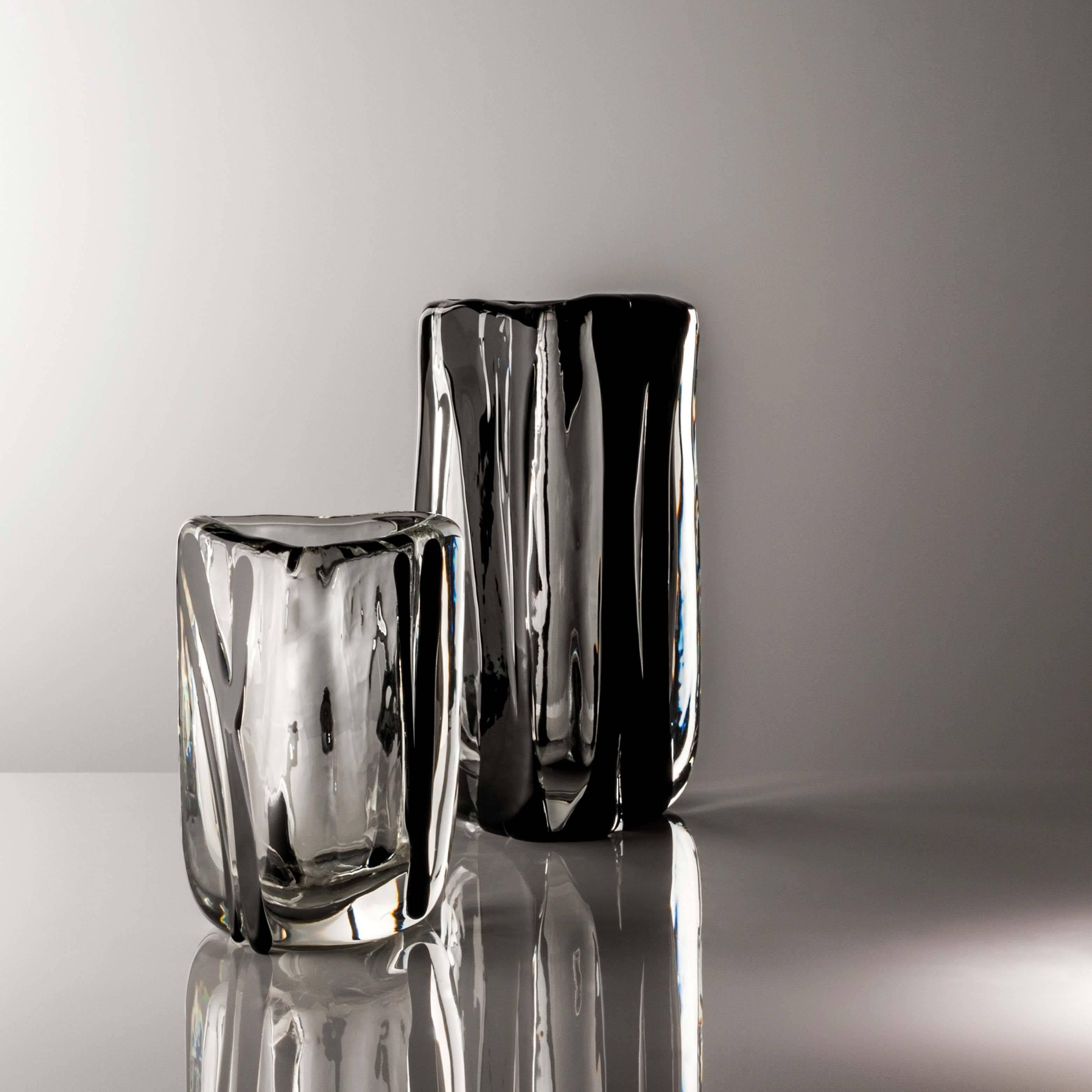 The Triangolo vase comes in three sizes and two different color-ways; the present example is the medium size with crystal and black decoration. 

This collection evolved from the architect's interest in the power of light and materiality. Subtle