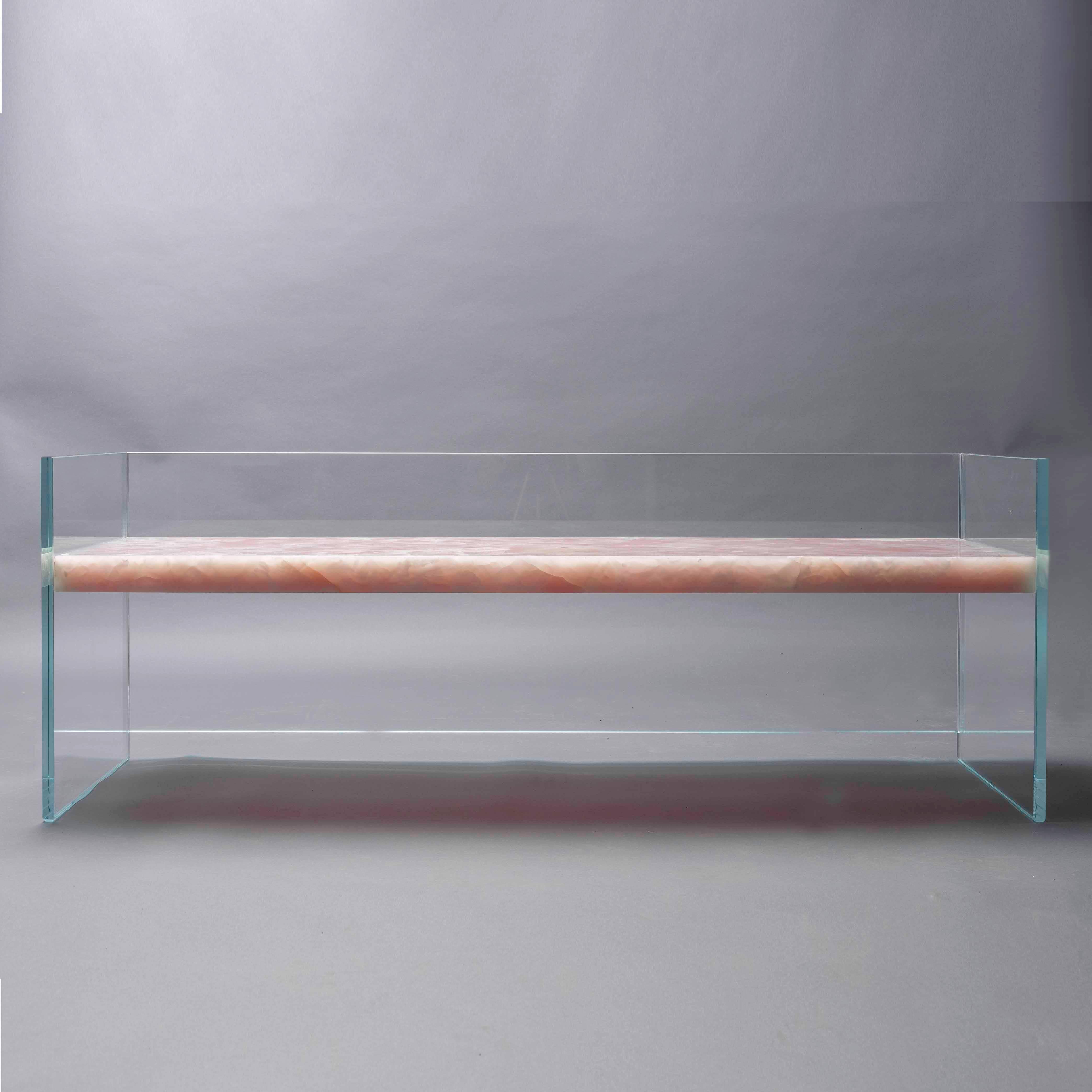 Sculptural bench made of ultra-clear glass and rose onyx.

Claste drew inspiration from the juxtaposition of stability and fragility to create this series of furniture designs. Each work embraces tension rather than reject it, transforming the