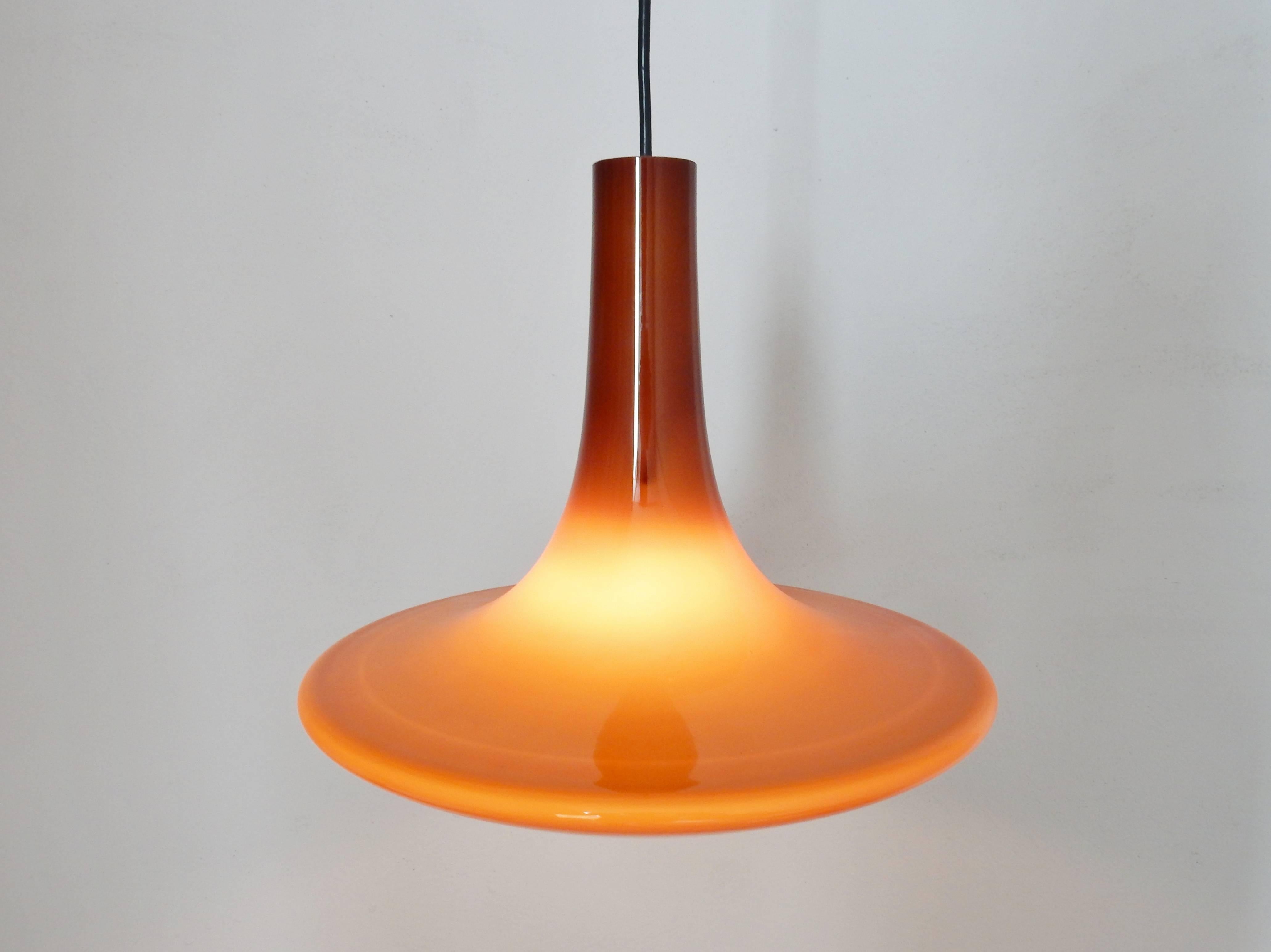 Superb pendant by the company of Peil and Putzler from Germany. The glass consists out of two layers. A white inner layer and a brown outside. The glass is from the island of Murano in Italy. 
When lit, the white inside softens the light into a