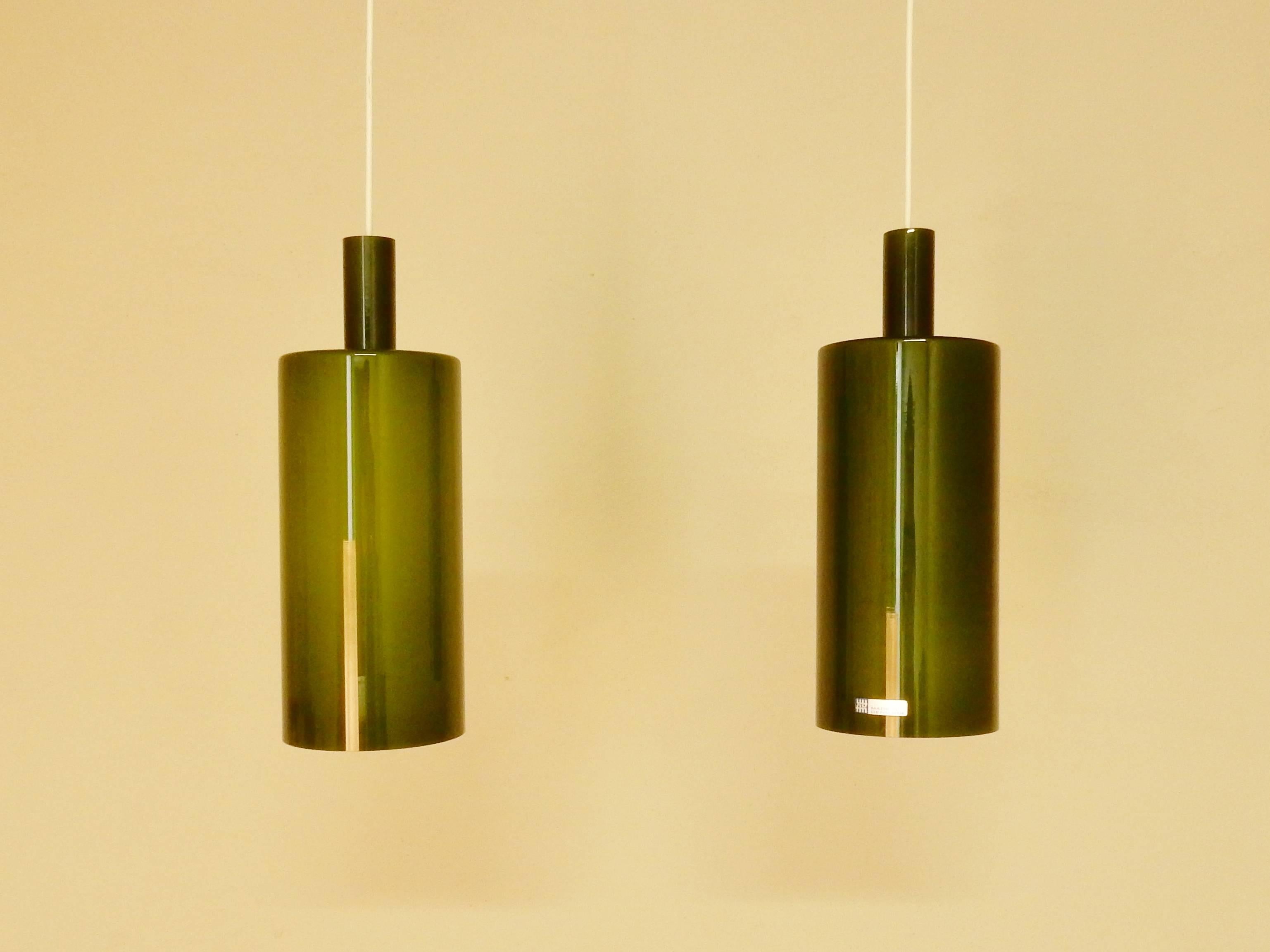 Set of two perfect conditioned glass pendants in olive green glass. This pendant lamp is a design by Jo Hammerborg for Fog & Mørup. In 1968 this light was shown in the catalogue of F&M. Later on also in the catalogue of 1974-1975. This set of two is