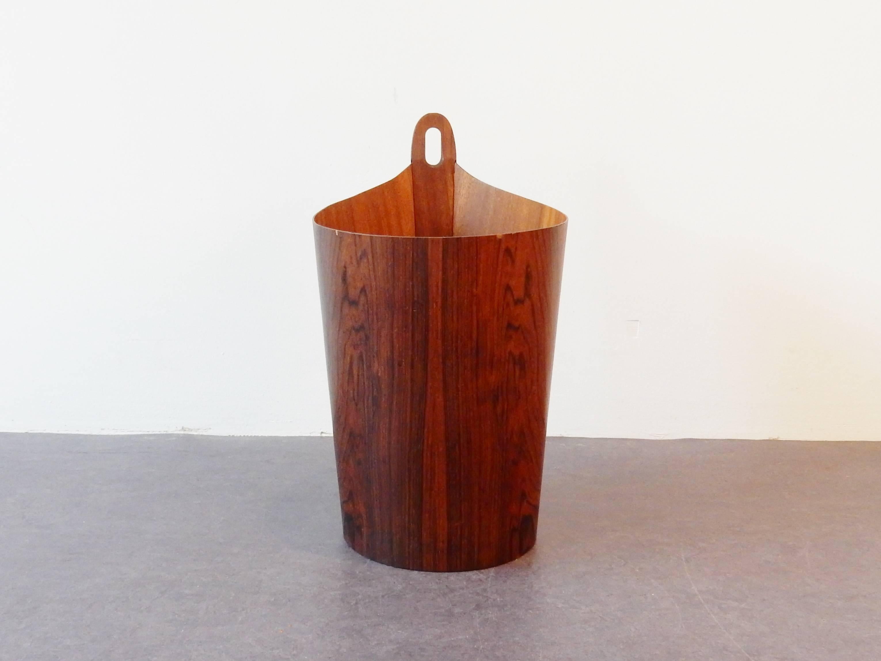 This wastepaper basket is the more rare version of the designs by Einar Barnes for P.S. Heggen from Norway. The basket is in a very good condition considering age and use with some signs of age to the upper edge, some loss of veneer such as