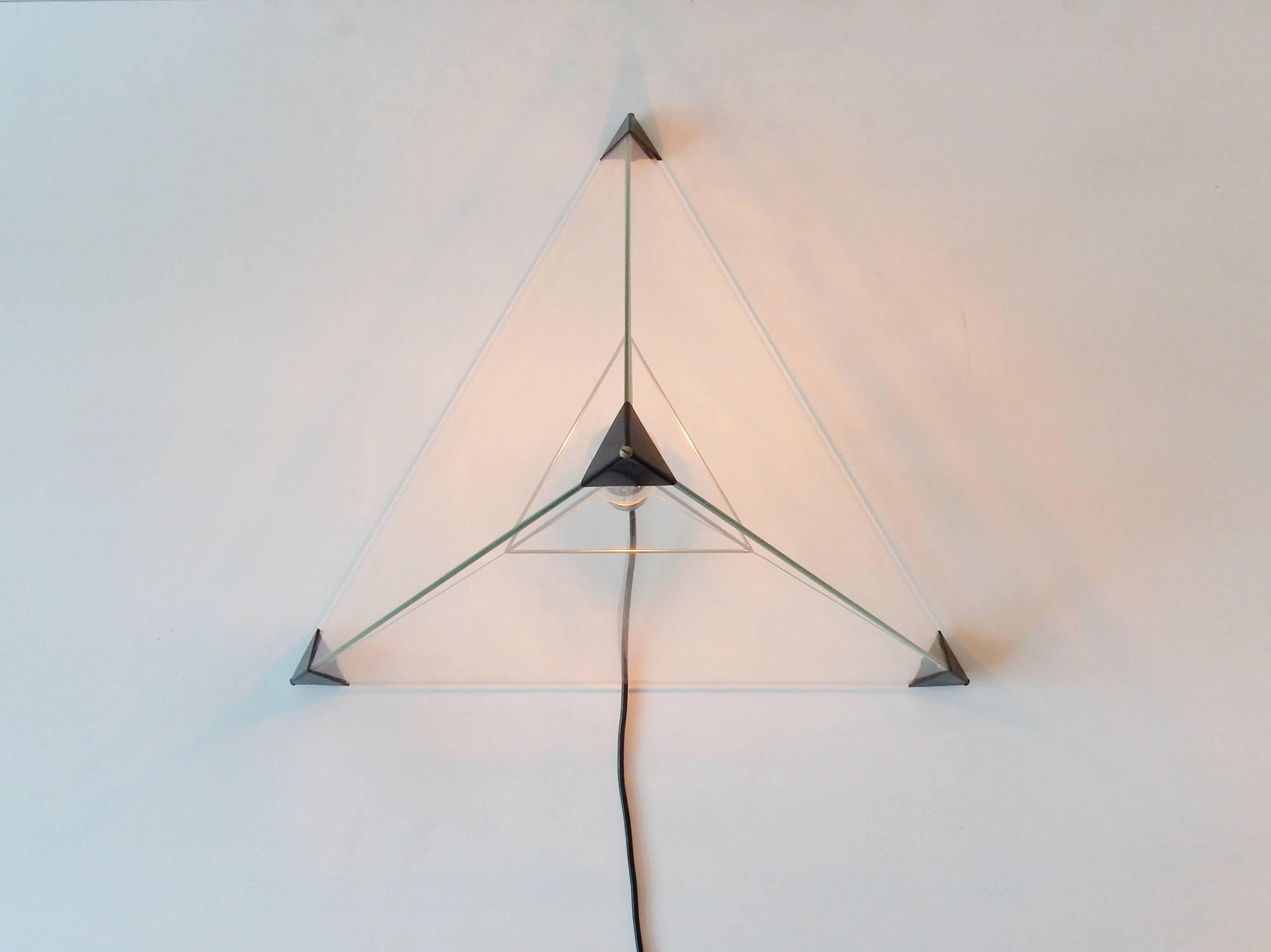 This beautiful lamp is called the 'Tetrahedron'. A design by Frans van Nieuwenborg and Martijn Wegman for Indoor. The light consist out of three glass triangles held together by plastic corner pieces. These corner pieces are connected and held in