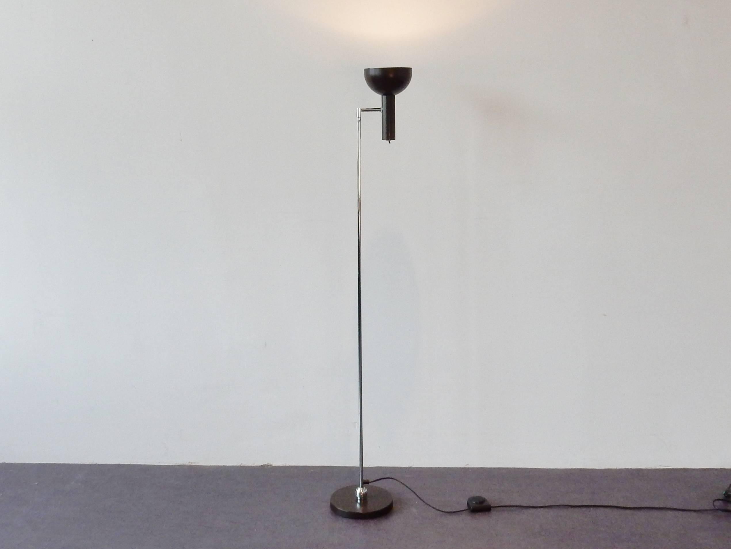 This floor lamp is in an almost as new condition. The dark brown lacquer has maintained a great condition. This lamp can be moved to all directions due to the 'ball in socket' joint on the floor plate. The top hood can be moved around, as well as up