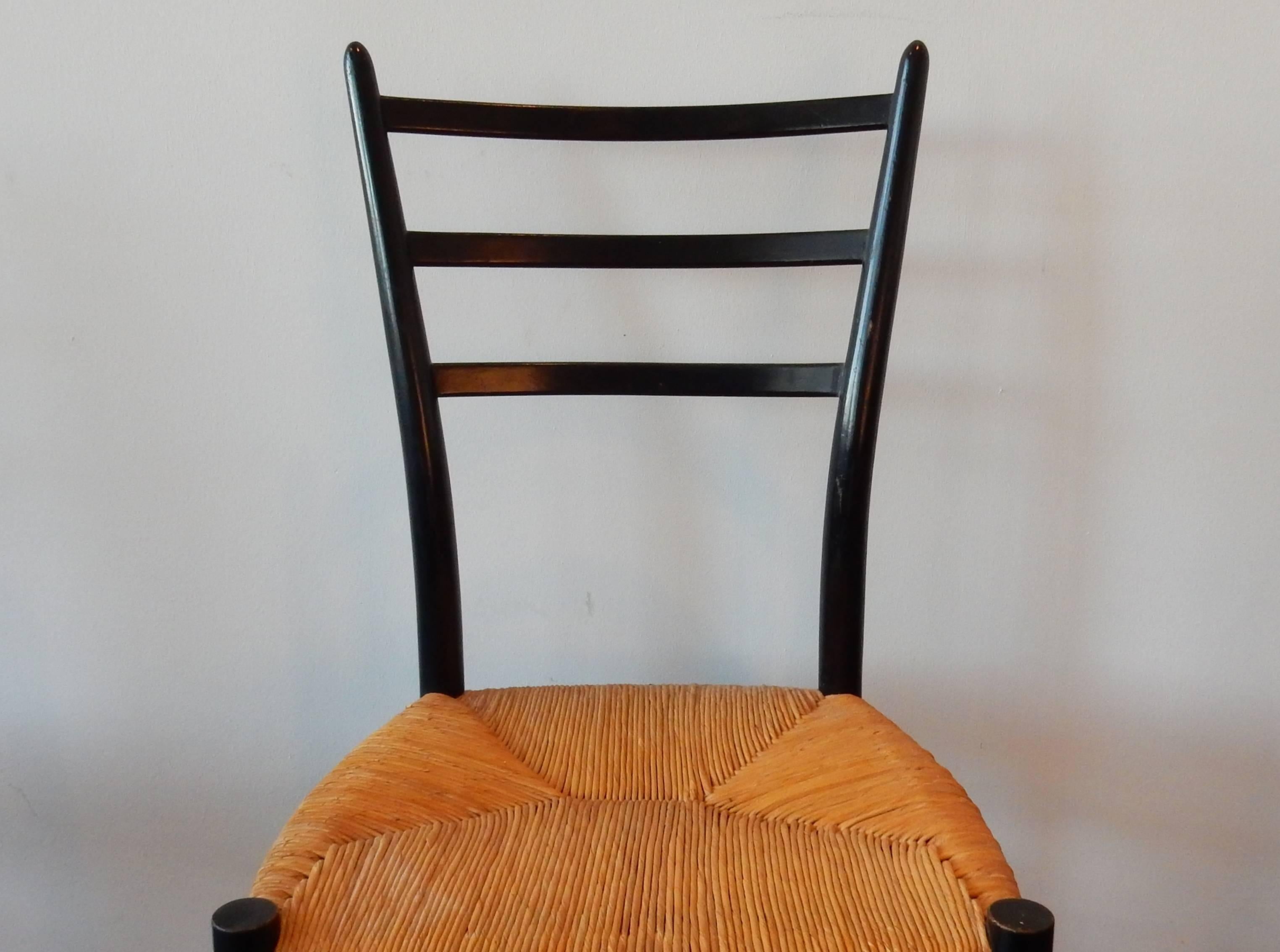 This is a fantastic set of five 'Spinetto' dining chairs by Italian manufacturer Chiavari. The ebonized wooden frames are in very good condition with some signs of age. All come with their floor rubbers. The wicker seats are in a very good condition