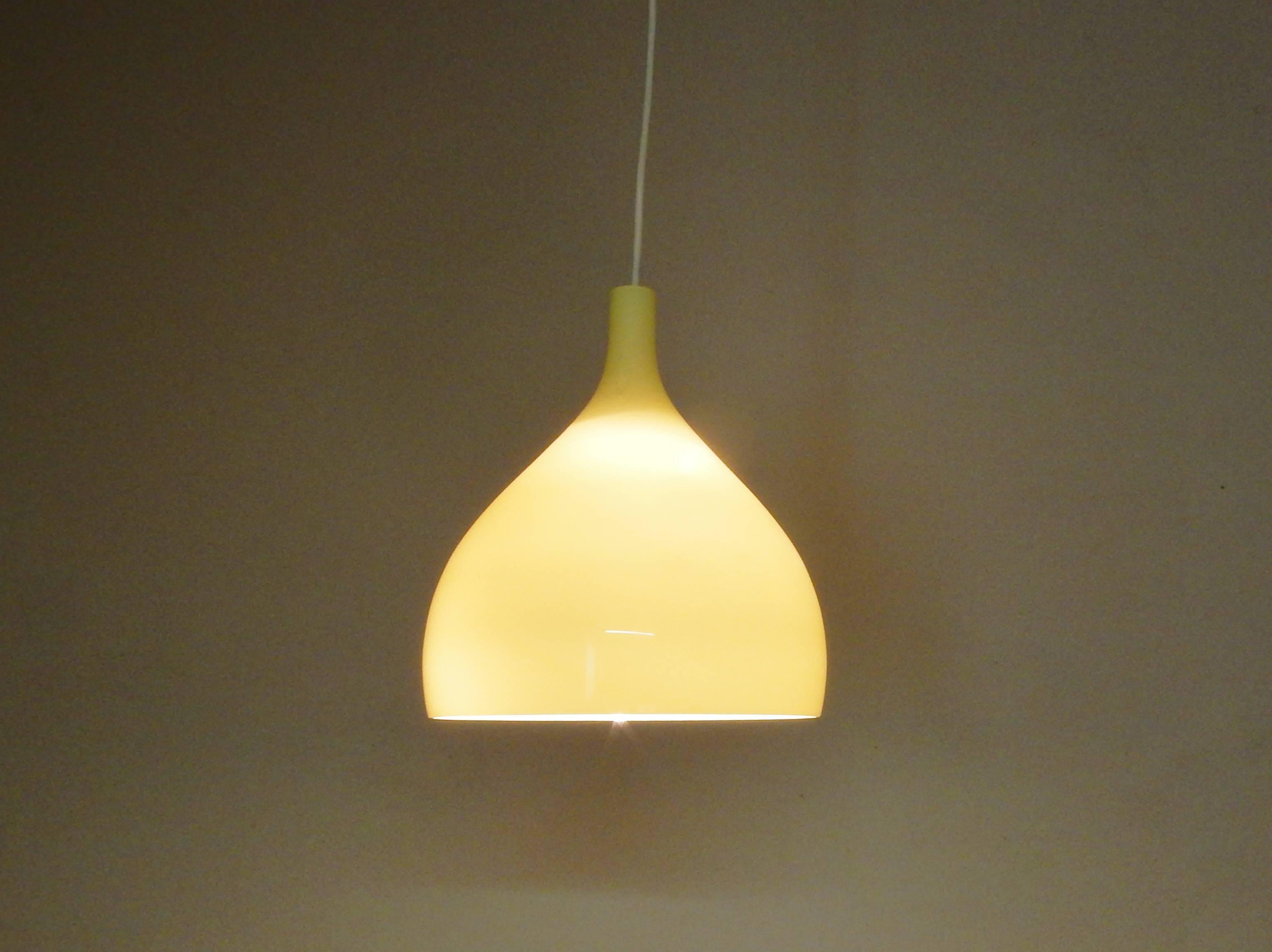 This glass pendant light is of a beautiful soft toned yellow color. The white inside softens and spreads the light beautifully. This light is a design by Massimo Vignelli for the Italian glass company of Venini, from the island of Murano.

It