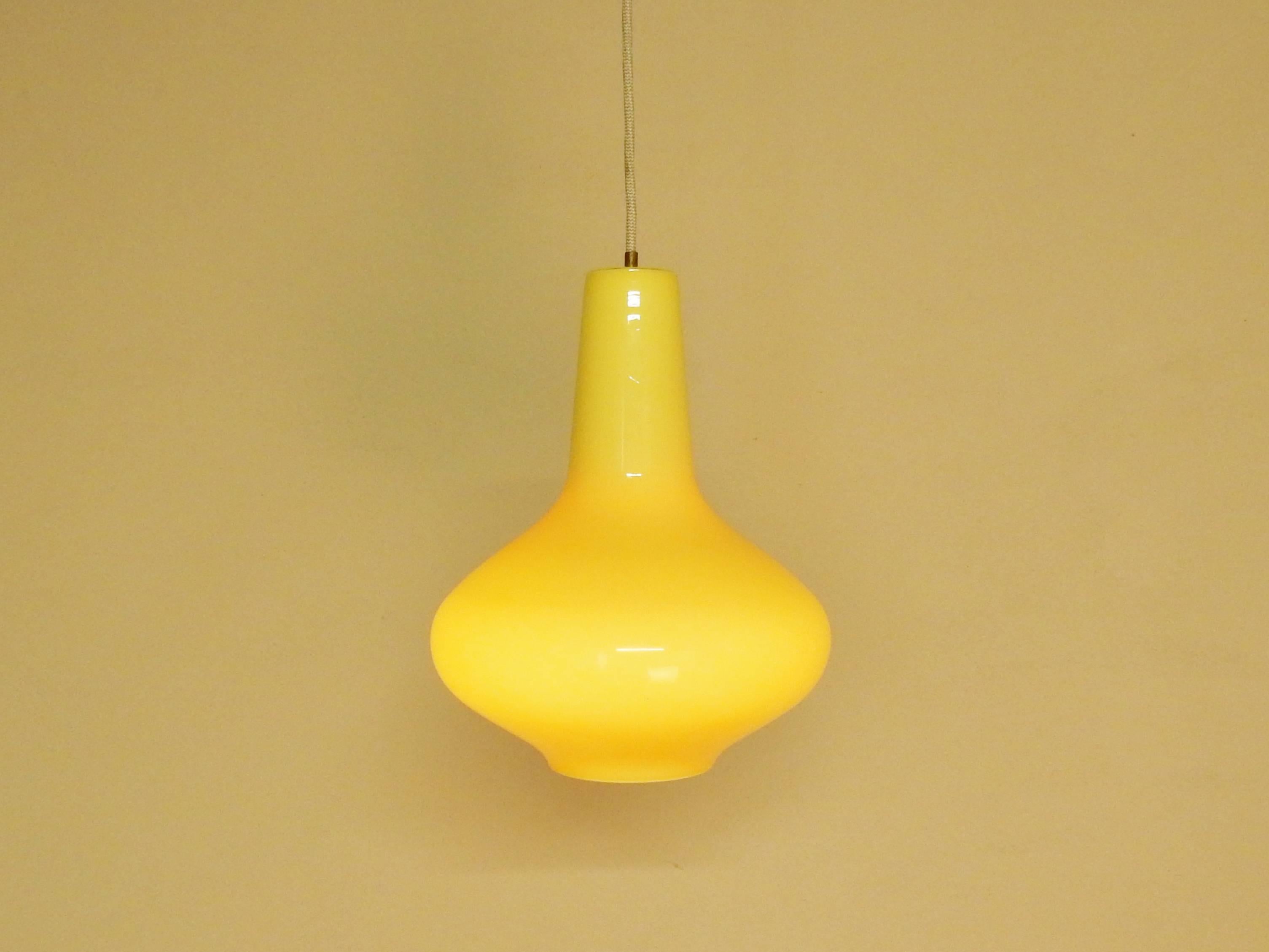 This soft tone yellow glass pendant lamp is in a very good to excellent condition. Soft yellow glass outside with a white opaline inside. This gives a very nice and soft light. Documented in the 'Indoor' catalogue of 1967.
Indoor was the Dutch