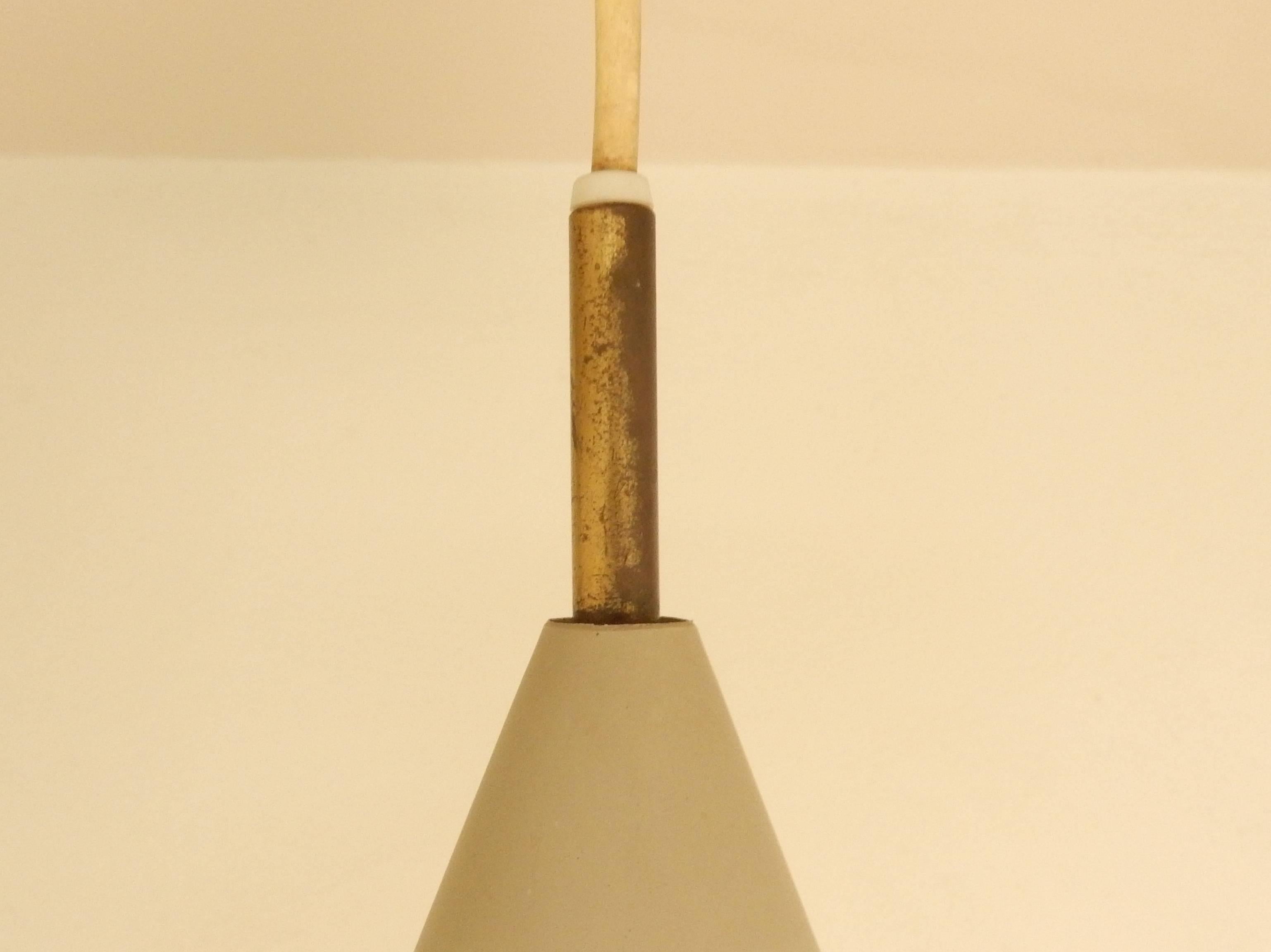 This lovely small pendant light is a design by Svend Aage Holm Sørensen for Lyfa from the 1950s. Only few models are known with these two cones. Usually the cones are separately carrying a bulb. With this model the two cones are on top of each