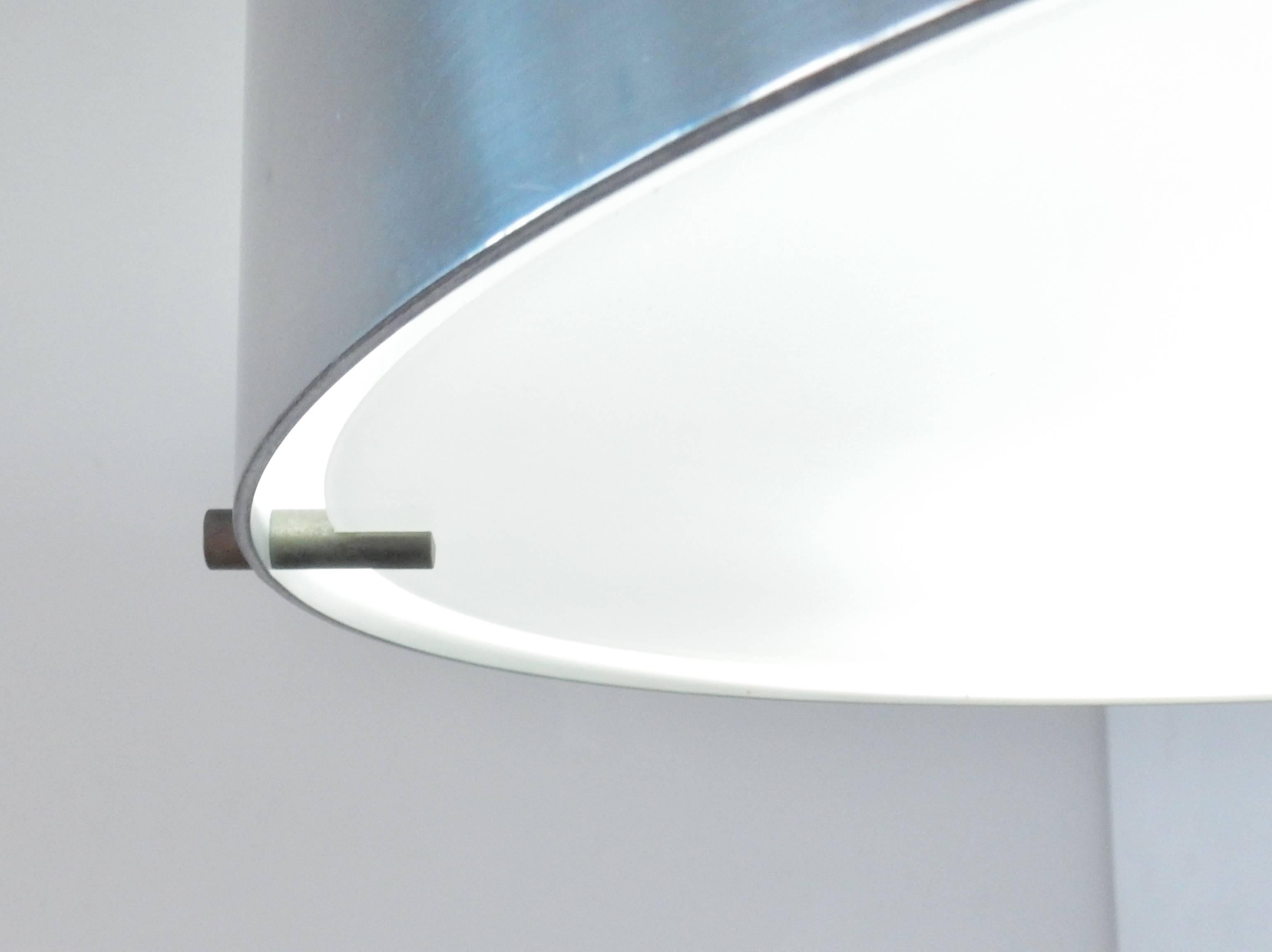 This light is a design by Bruno Gatta for Stilnovo. 
We have ten wall sconces of a chromed circle on a white wall fixture available.
We have more lights available of this model, but with different colors to the wall fixture.
All in a very good