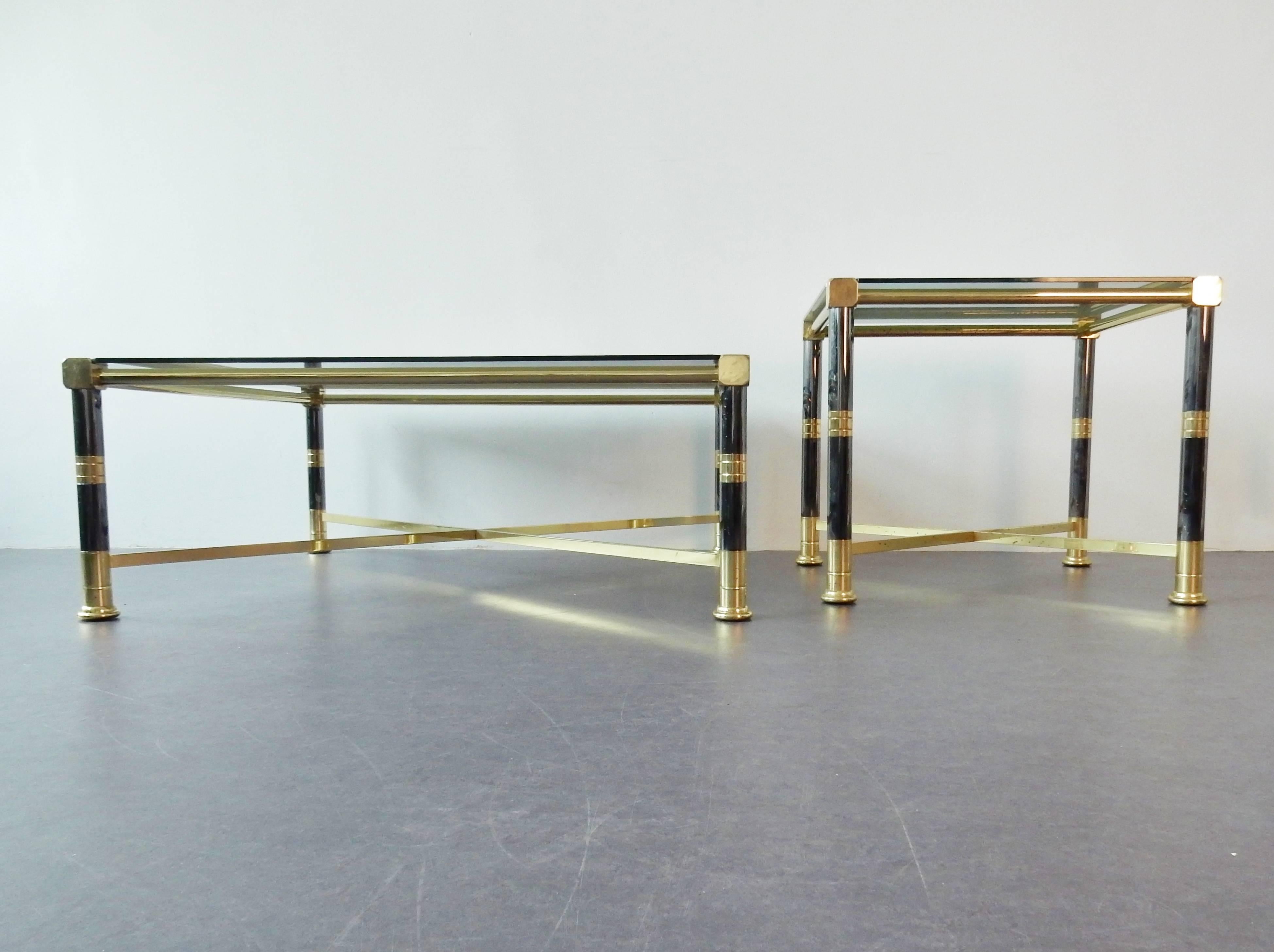 Set of 2 tables in grey metal (bit like petrol blue) and brass with a smoked glass top. All in very good condition with some smaller signs of age and use. No chips or damages to the glass top. This set is a great representation of the 