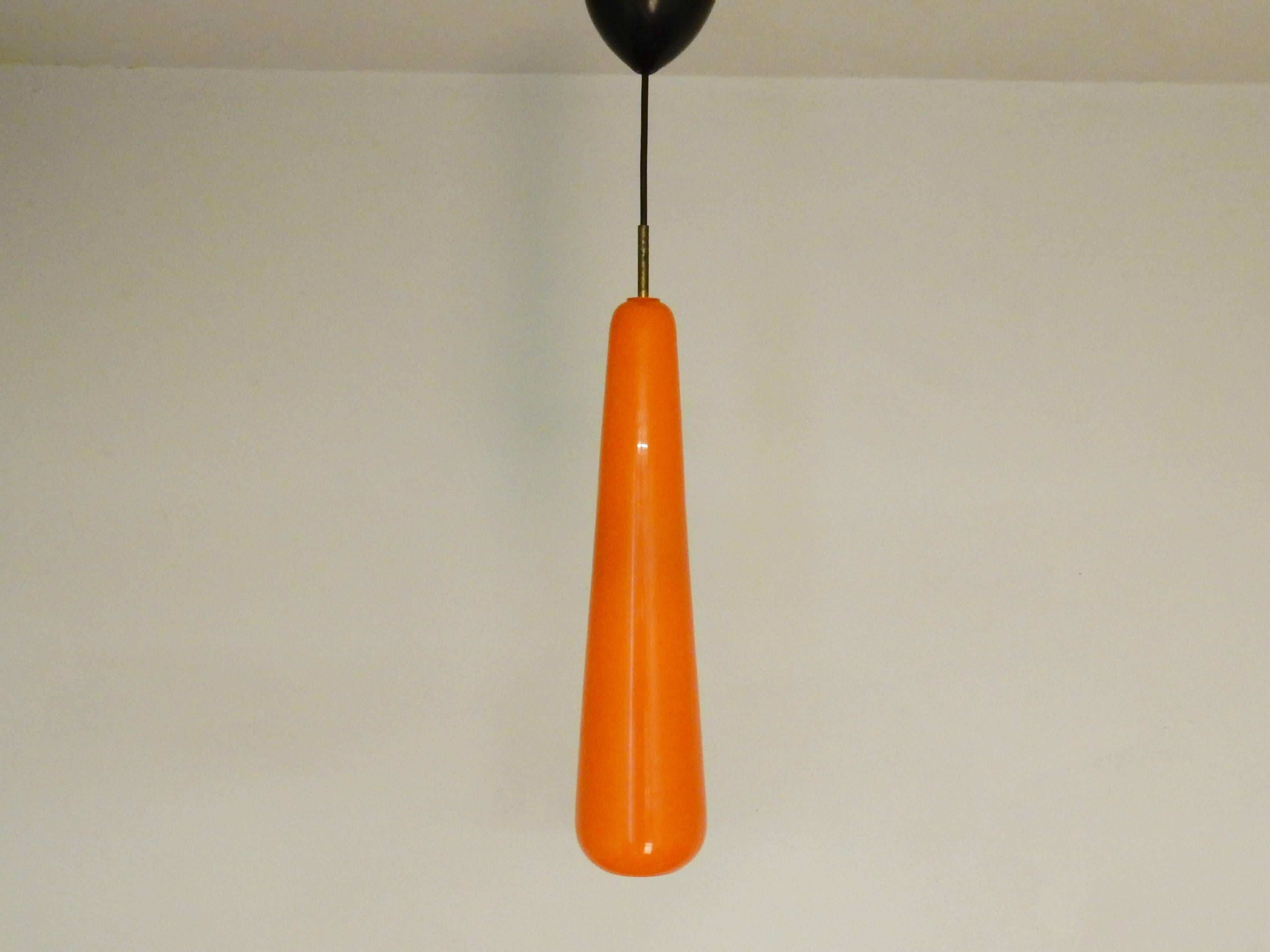 This set of two orange glass pendant lights is in a great condition. Fully original socket and brass fixture, with new wiring. 
These two lights are a design by Gino Vistosi and are in a bright orange color with an opaline white inside that gives a