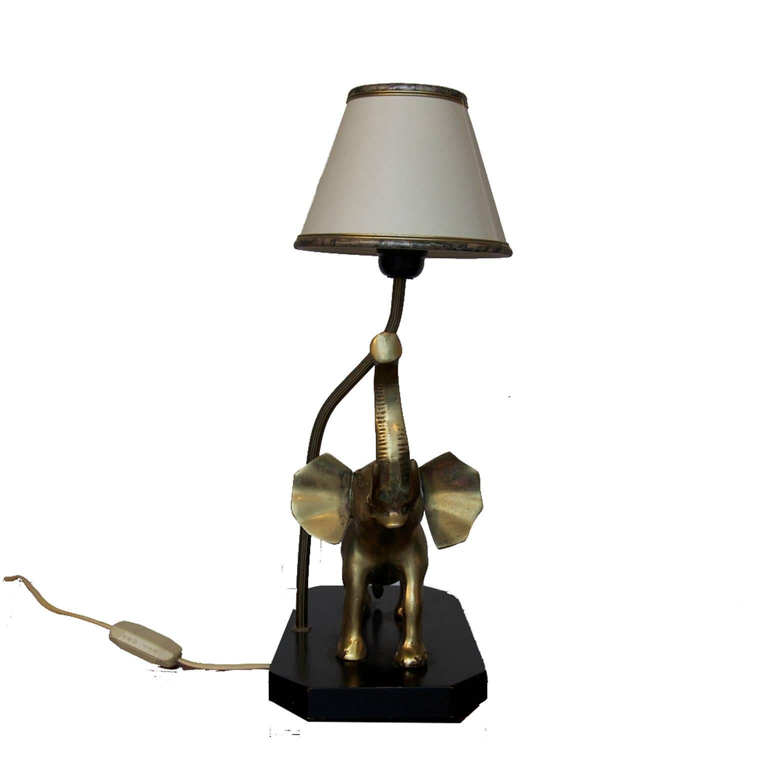 Table lamp with a brass elephant on a black wooden foot. With a off-white lampshade.

All our lights are checked and tested. Because of the lower voltage standard in the USA (110v vs 220v), European lighting can be safely used in the USA. If a